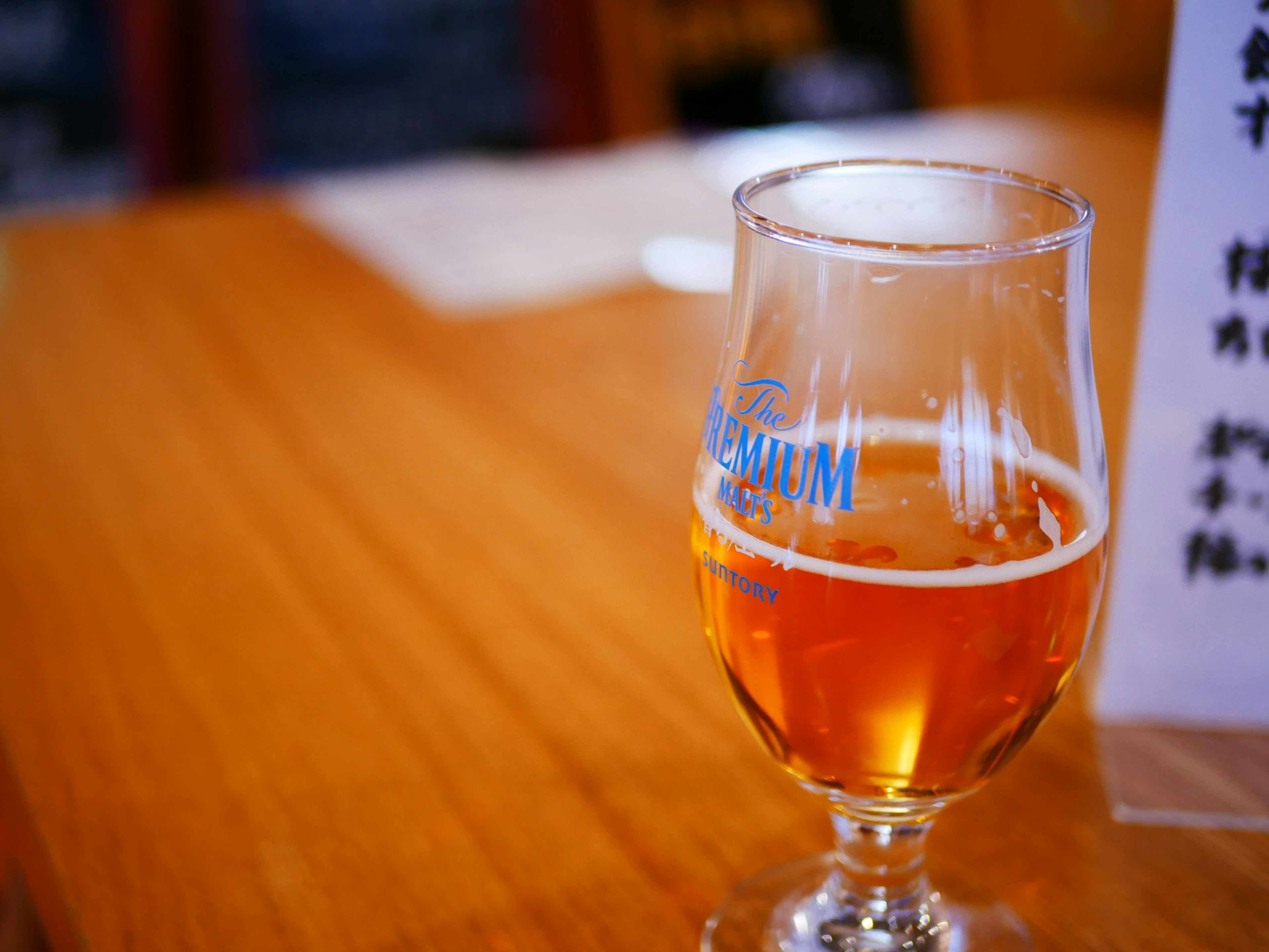 Amber beer in a clear glass on a wooden table