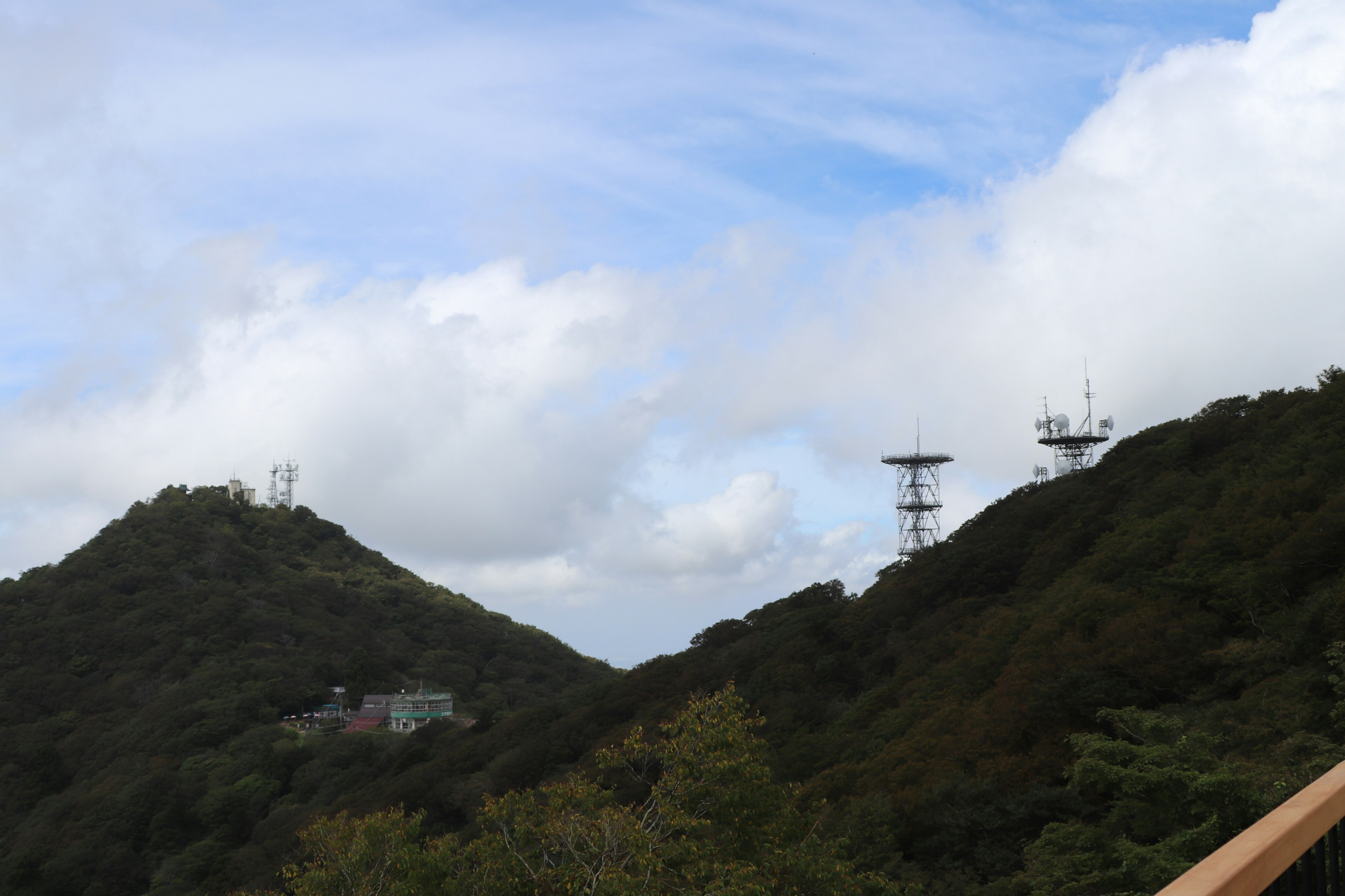 Berglandschaft mit Kommunikationstürmen unter einem bewölkten Himmel