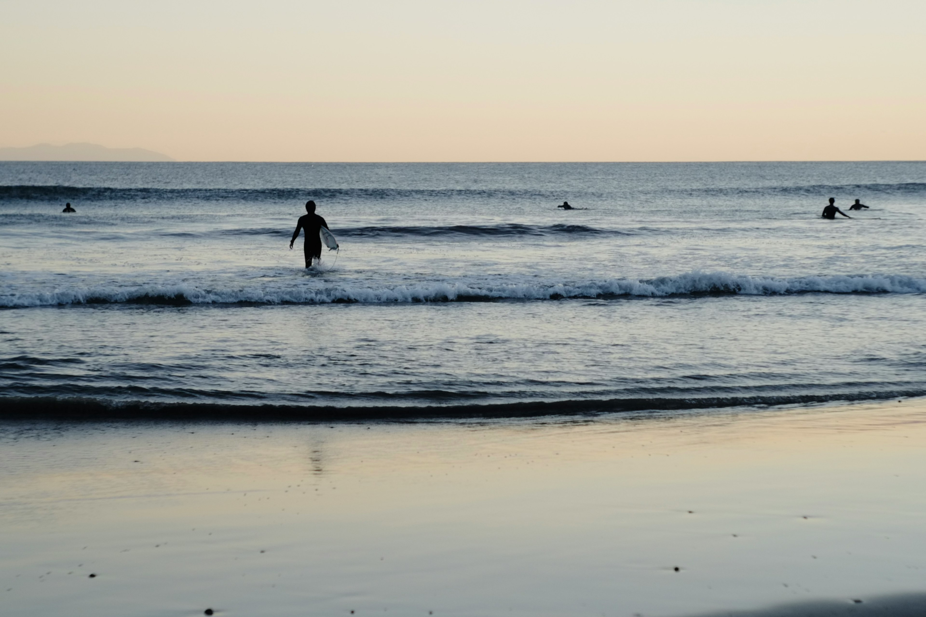 Silhouettes of people surfing in the ocean