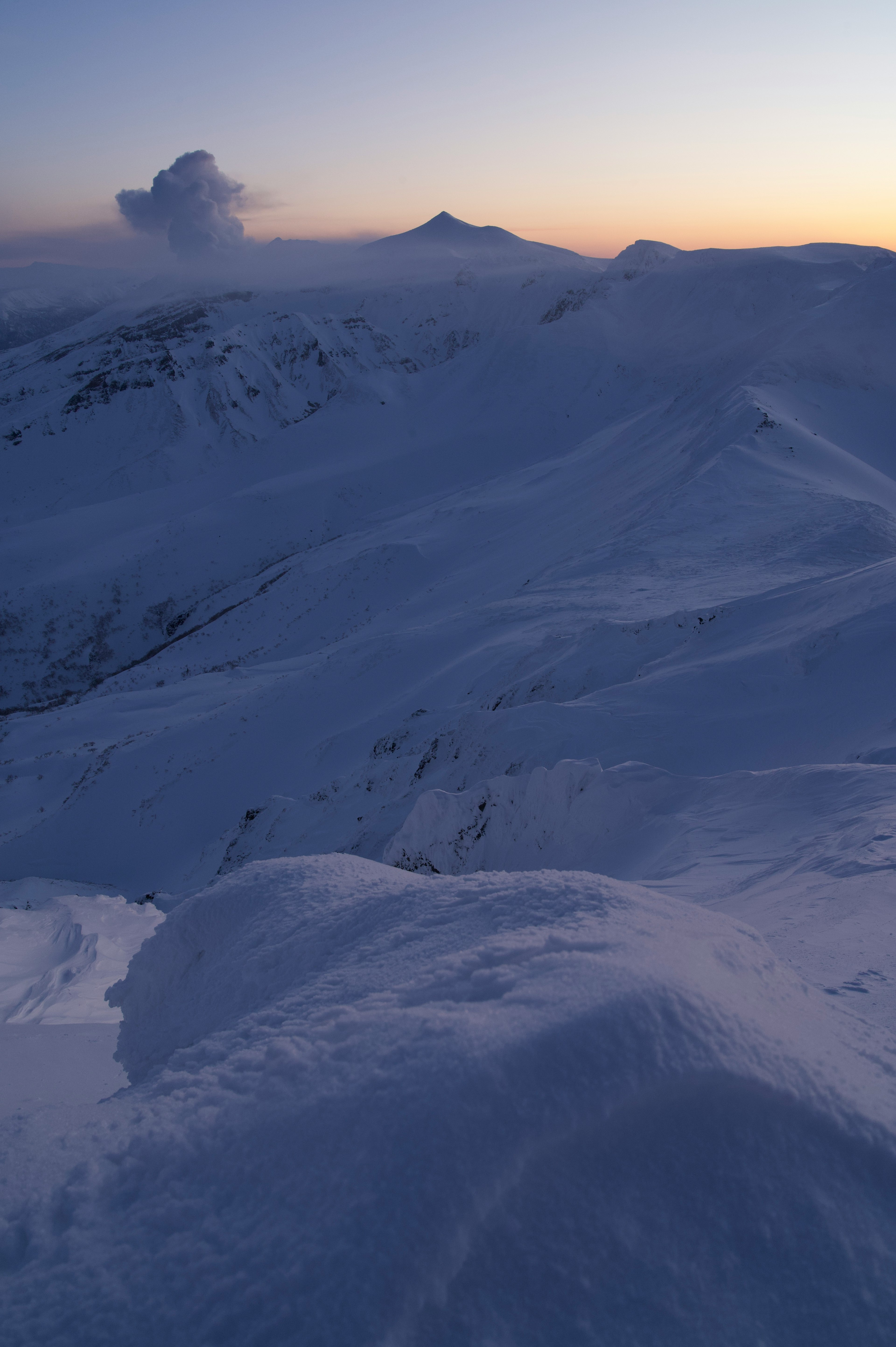 Schneebedeckte Berge mit einem Sonnenuntergangshimmel