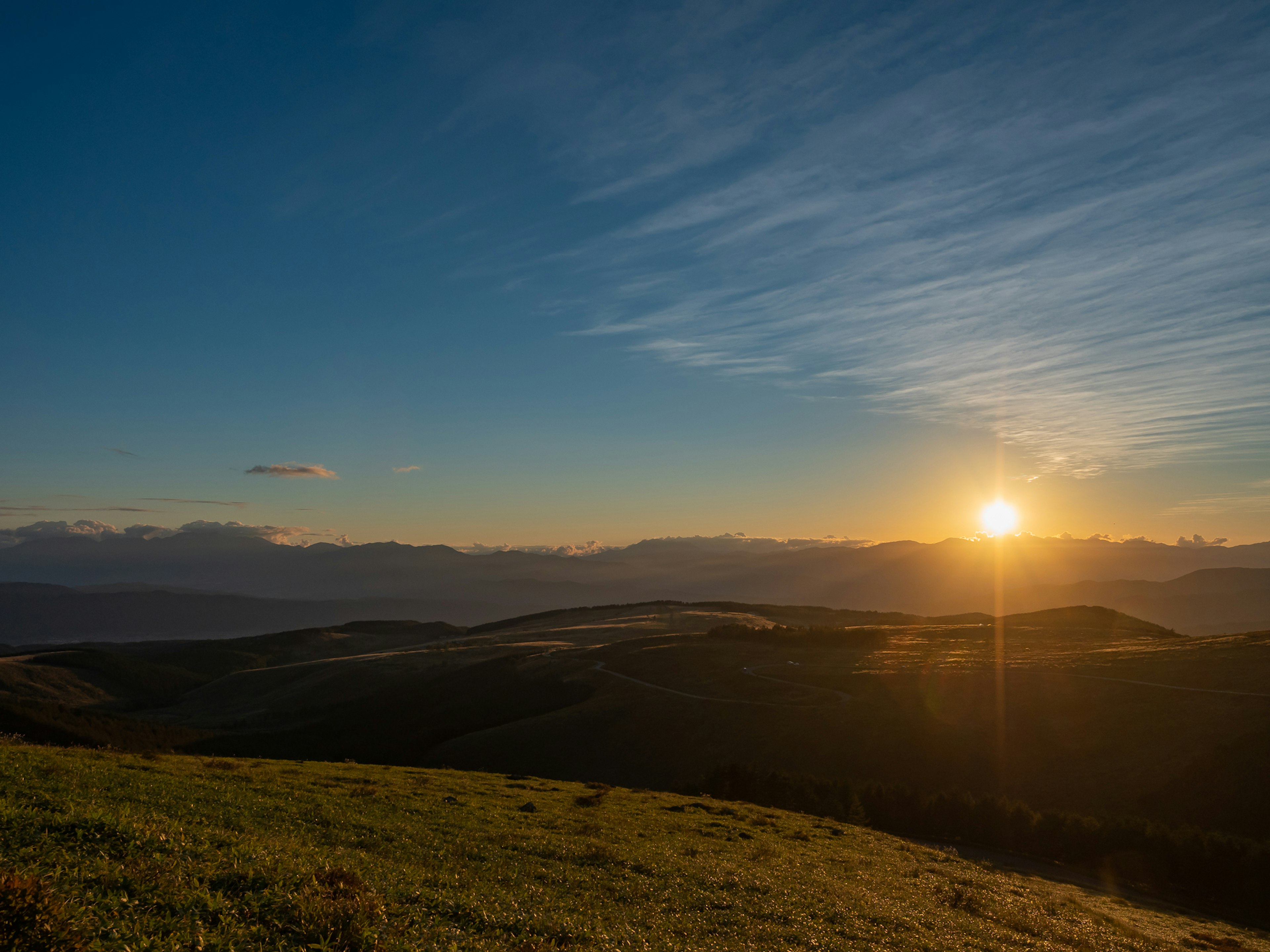 夕日が山々の間に沈む美しい風景