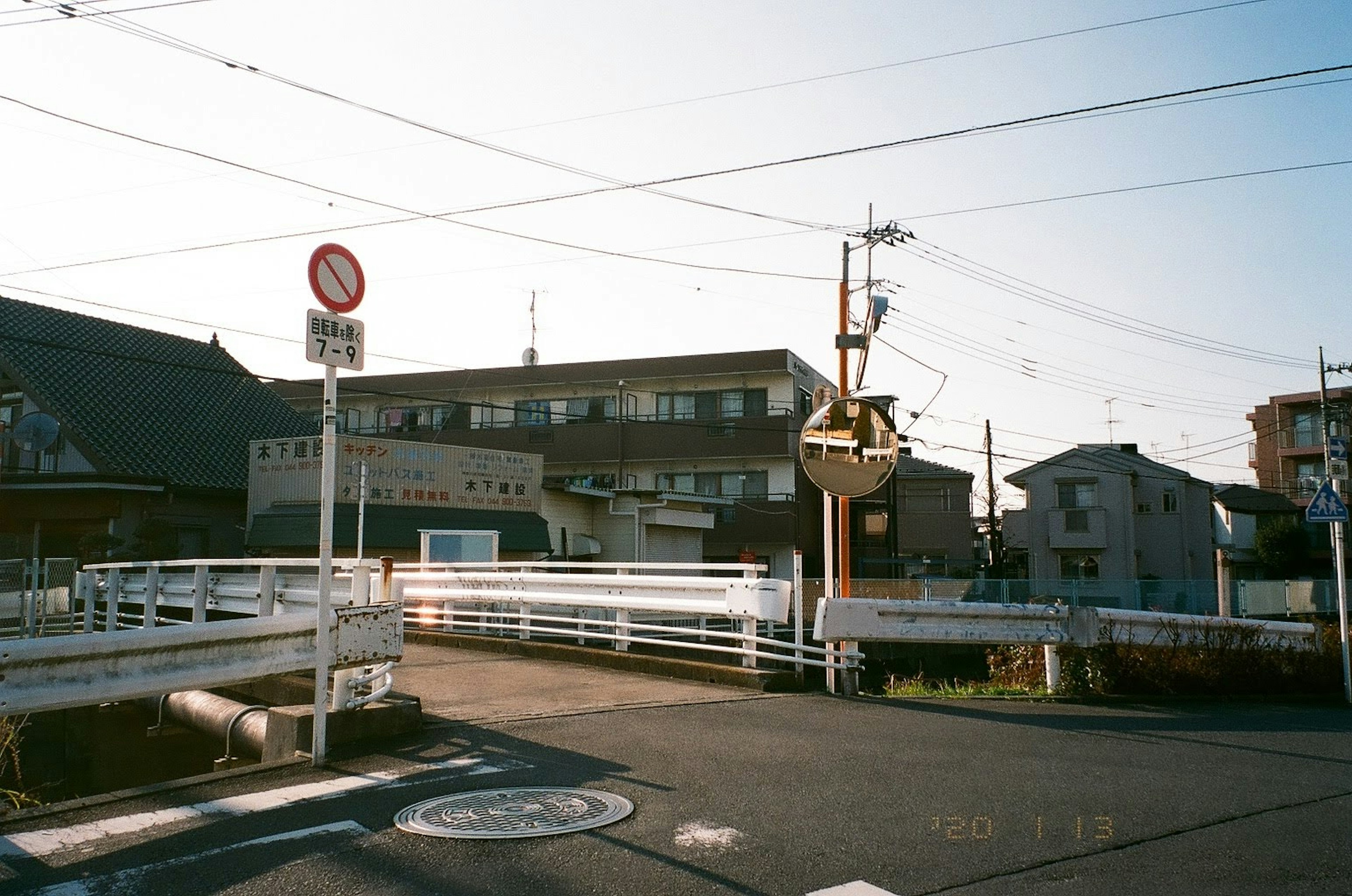 Intersection with traffic sign and white fence near buildings