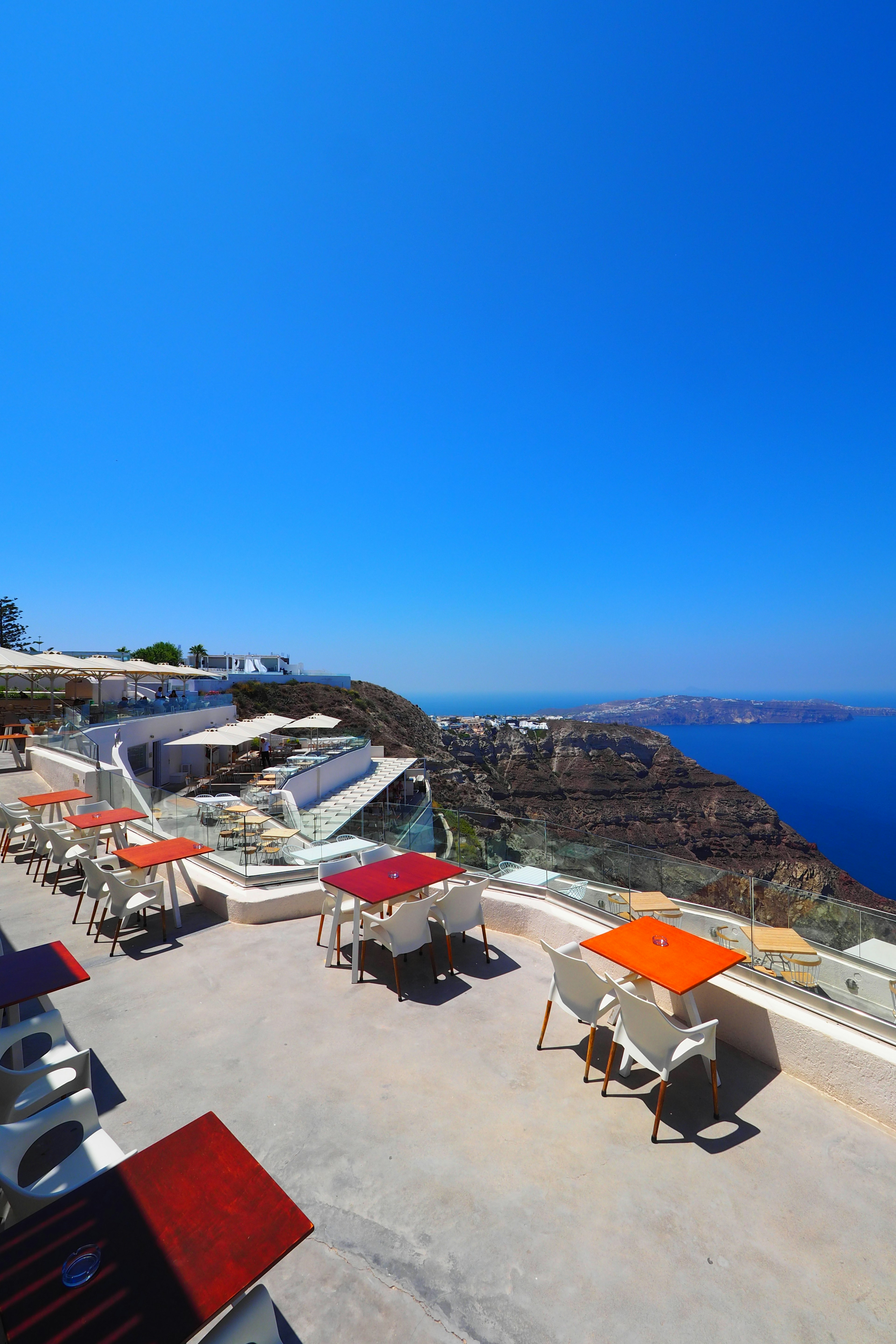 Bunte Tische auf einer Terrasse mit Blick auf das schöne Meer in Santorin