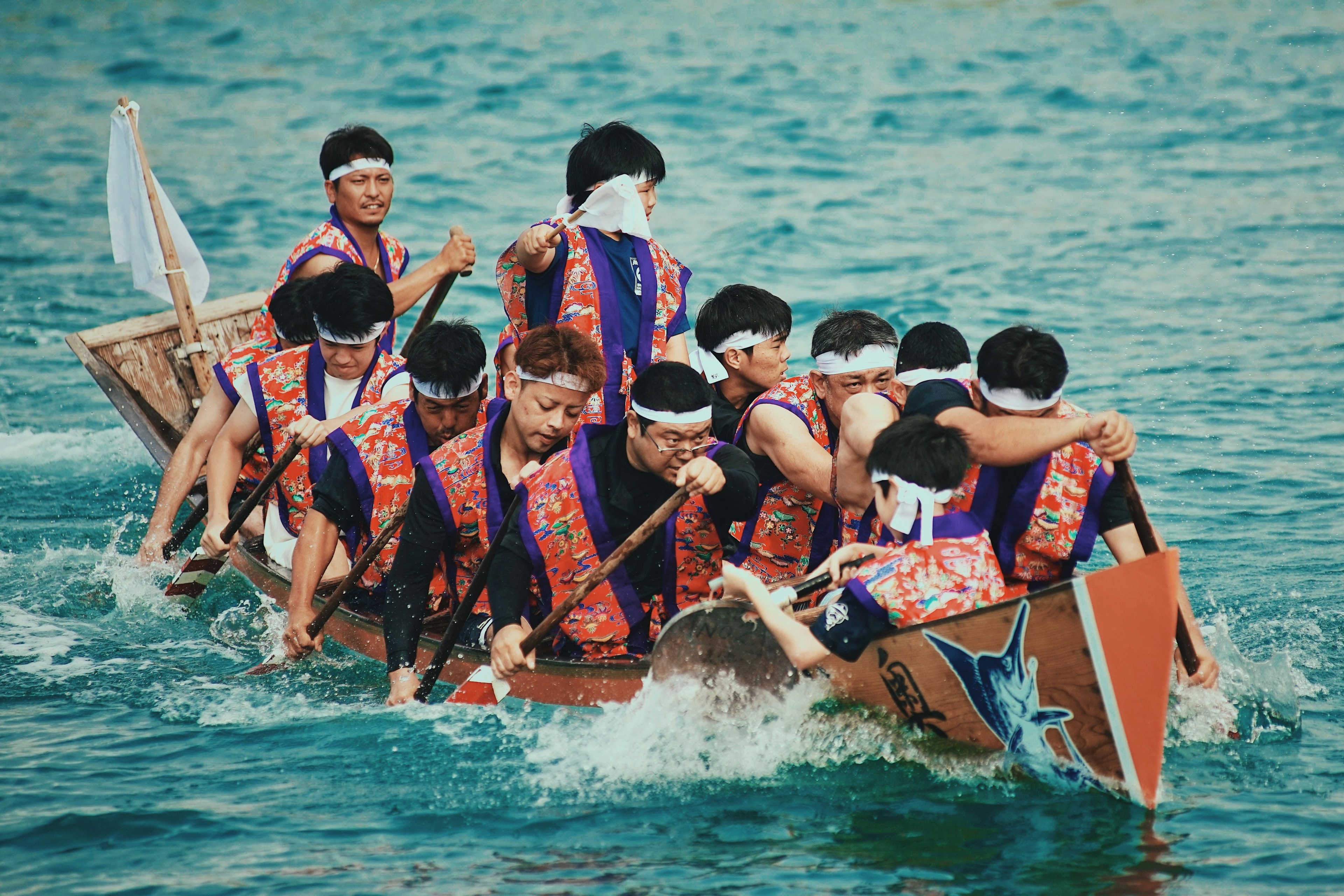 Equipo compitiendo en un bote tradicional sobre el agua