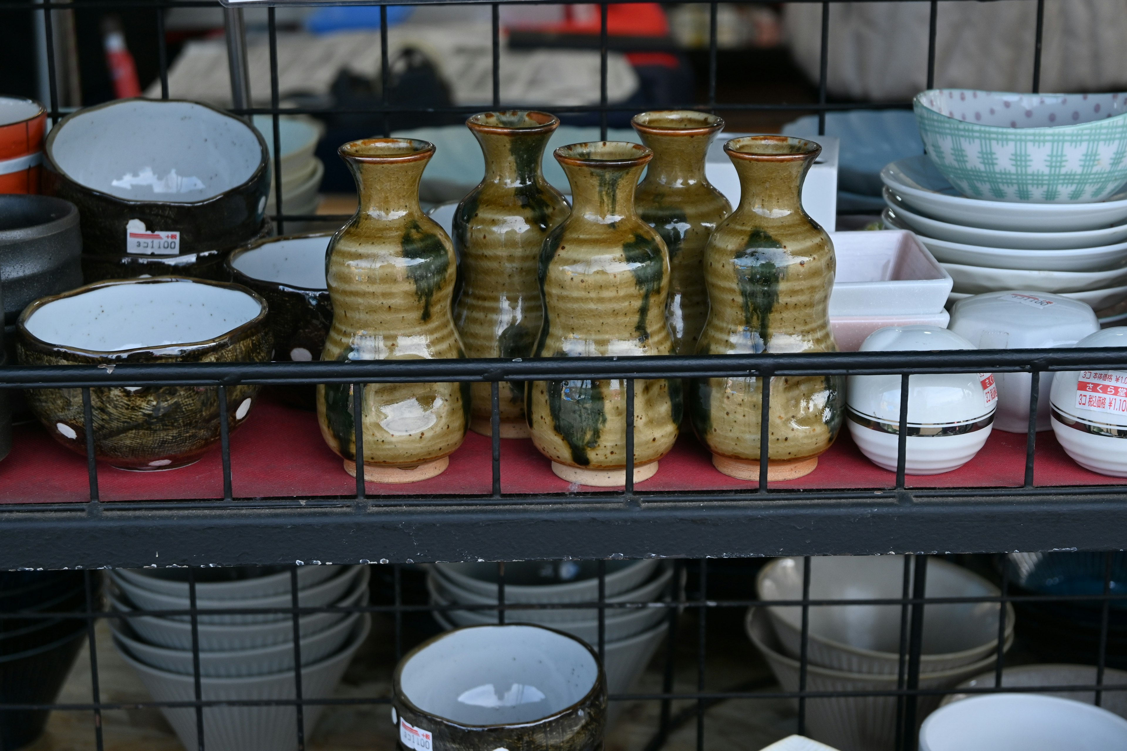 Image d'une étagère avec des bouteilles en céramique et divers plats