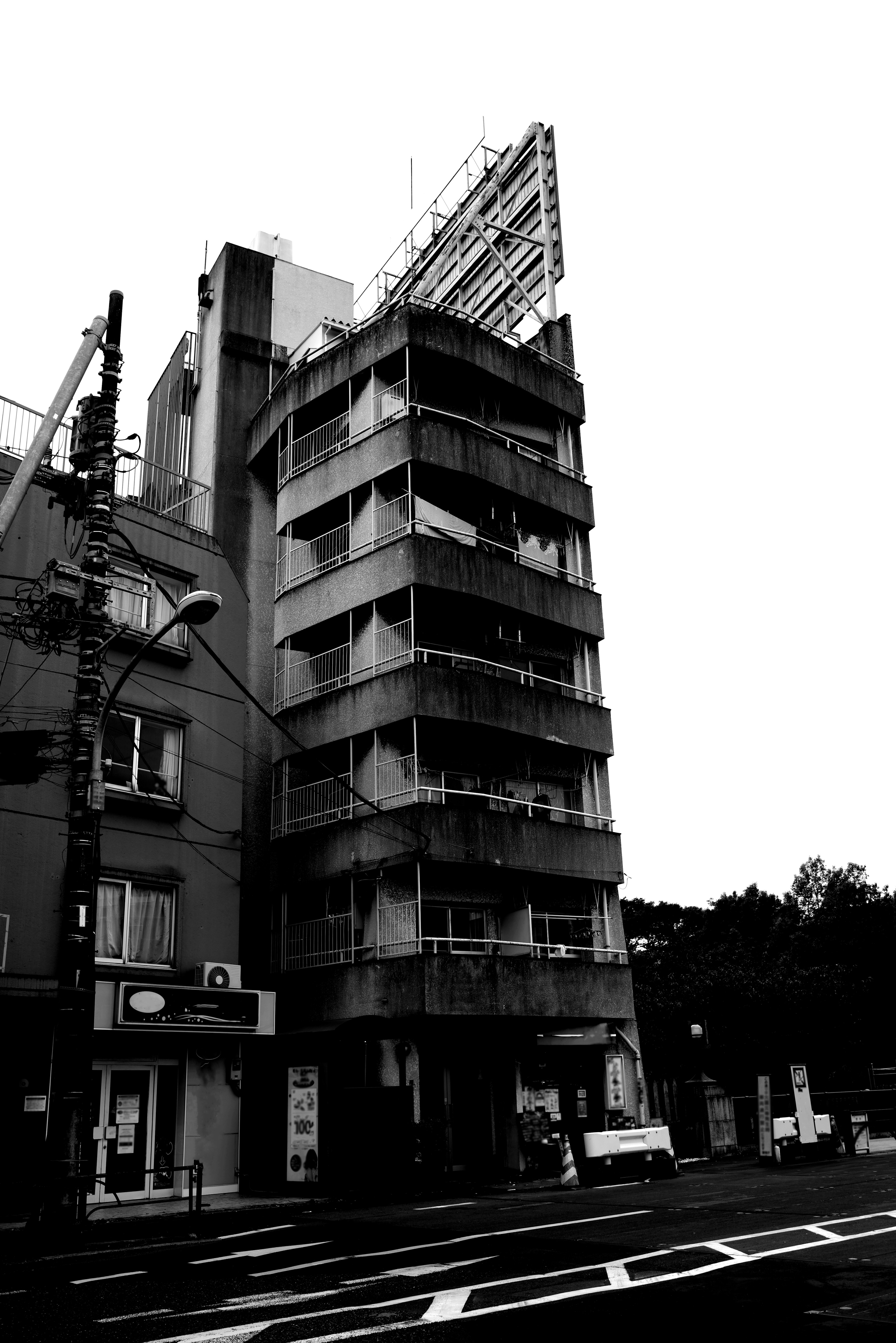 Image en noir et blanc d'un grand bâtiment au coin d'une rue