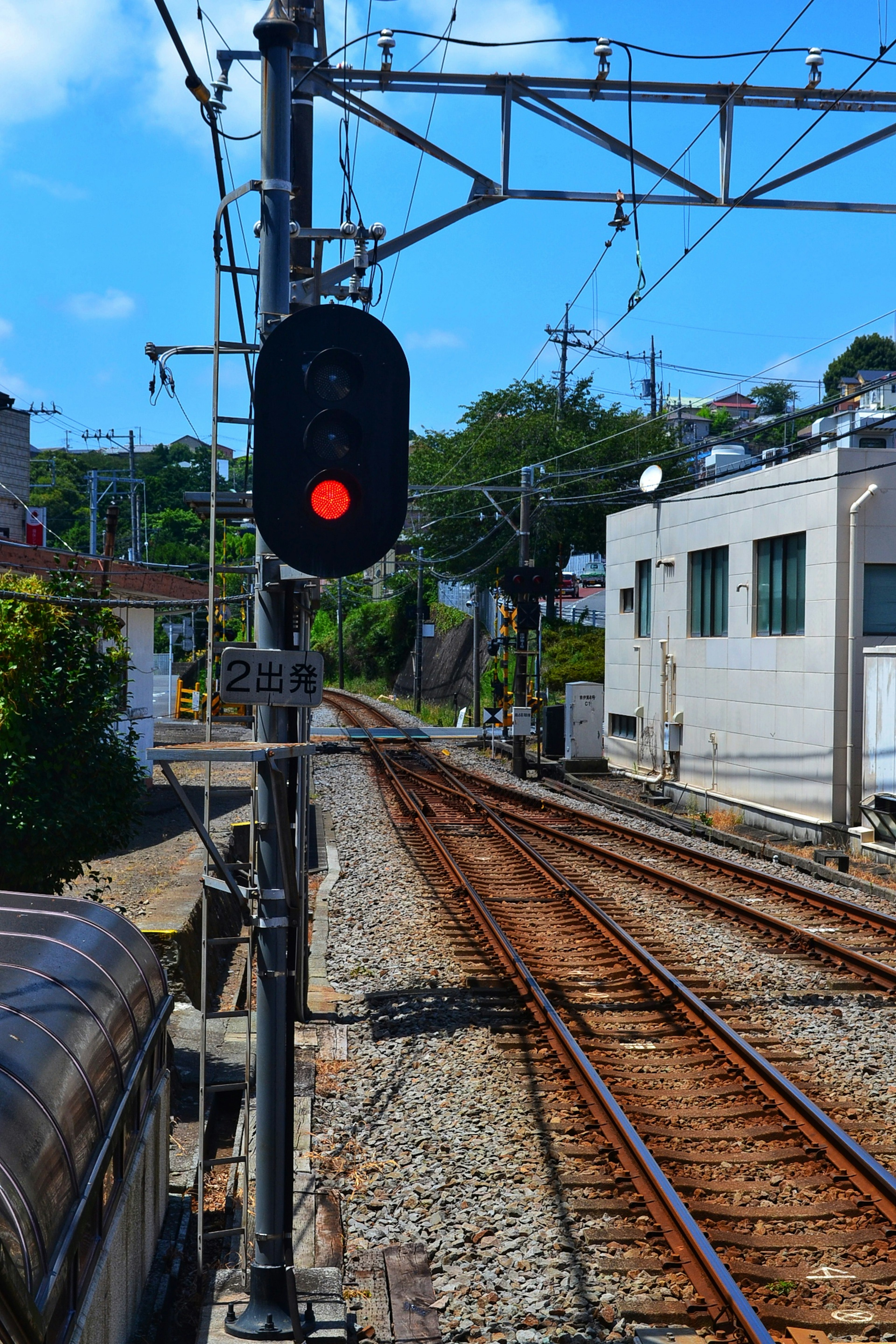 Señal ferroviaria con luz roja y rieles