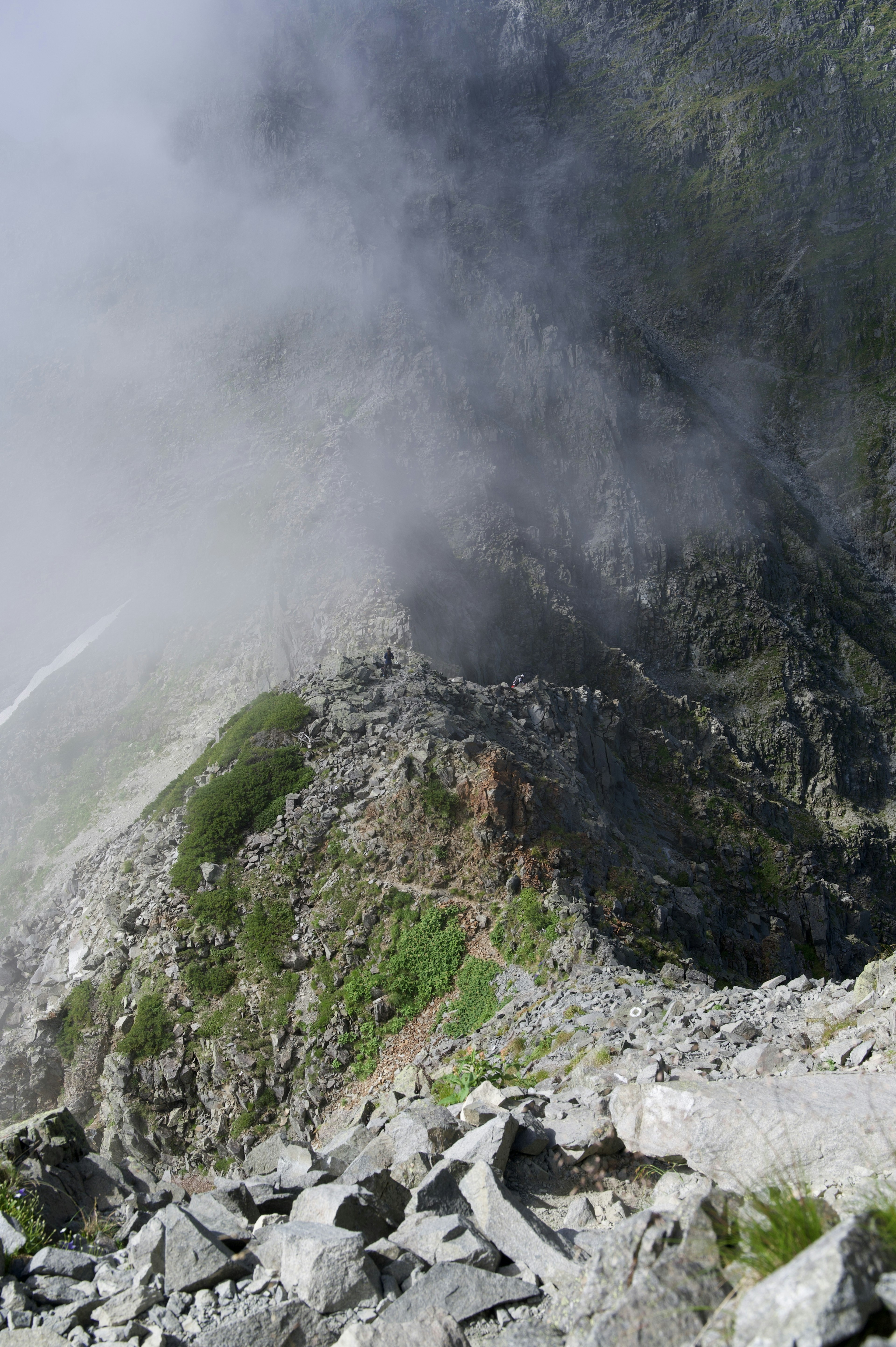 霧に包まれた山の風景 雲の中にある岩肌と緑の草地