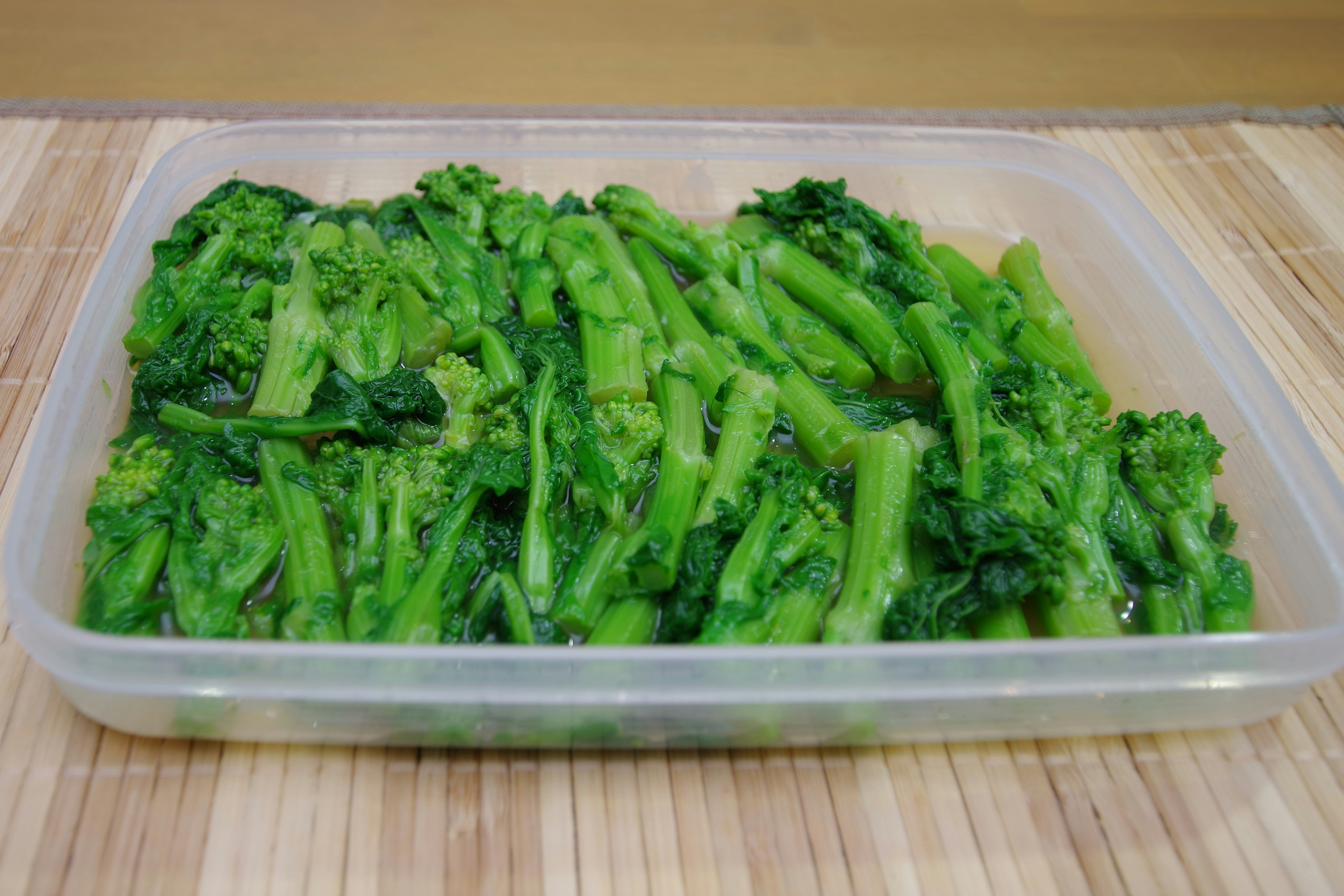 Imagen de broccolini en un recipiente transparente