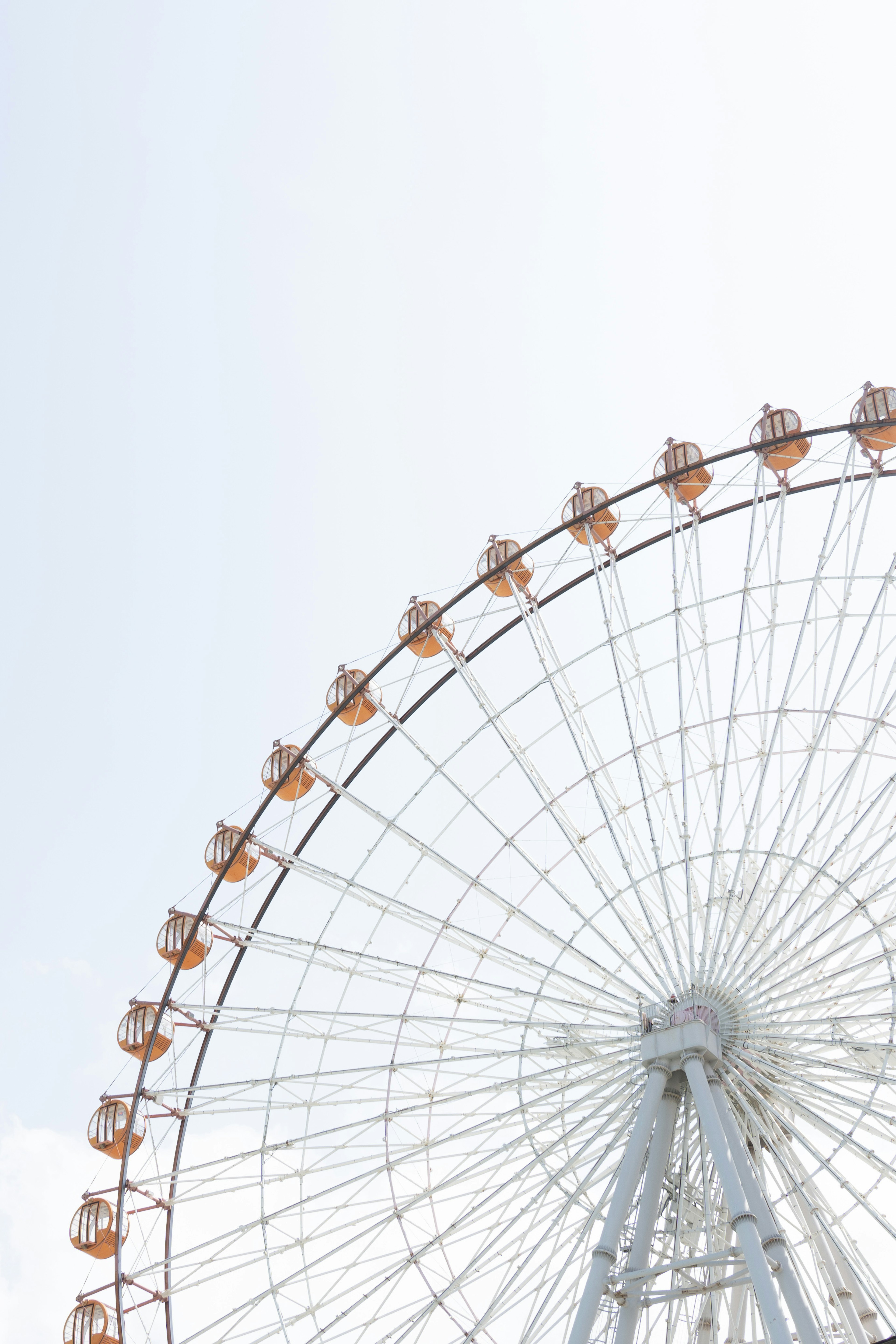 Upper part of a ferris wheel under a clear sky with gondolas