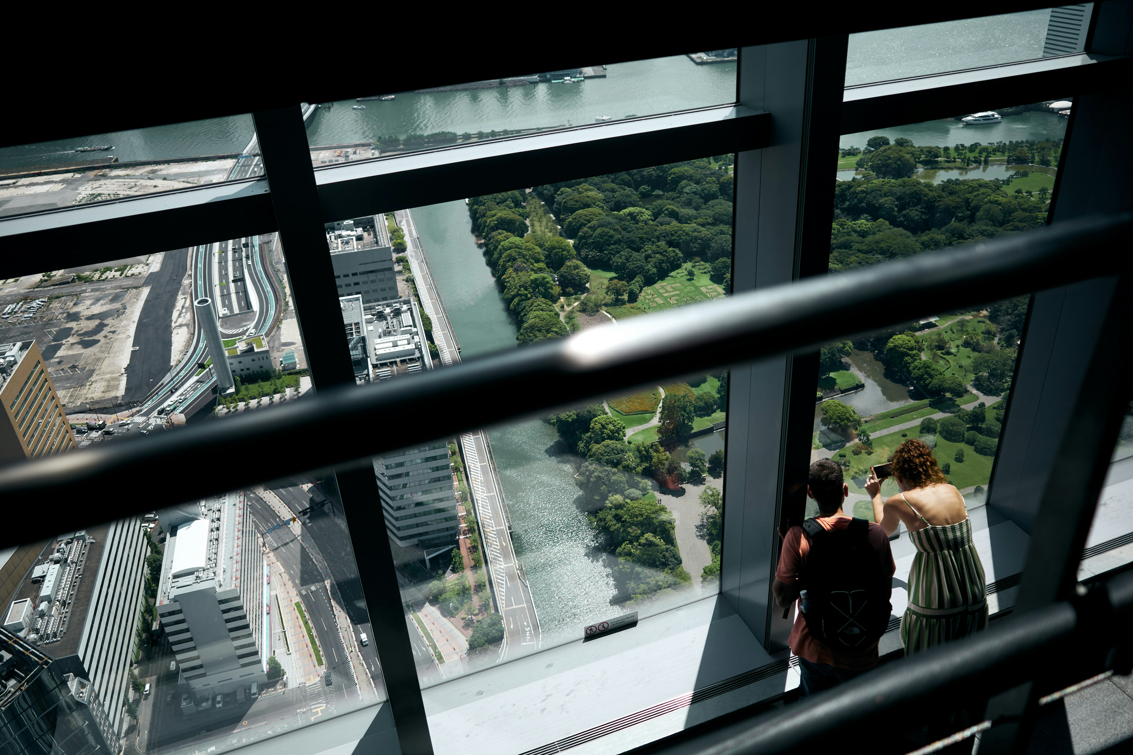 Vista desde una plataforma de observación alta con personas mirando la vegetación y el río abajo