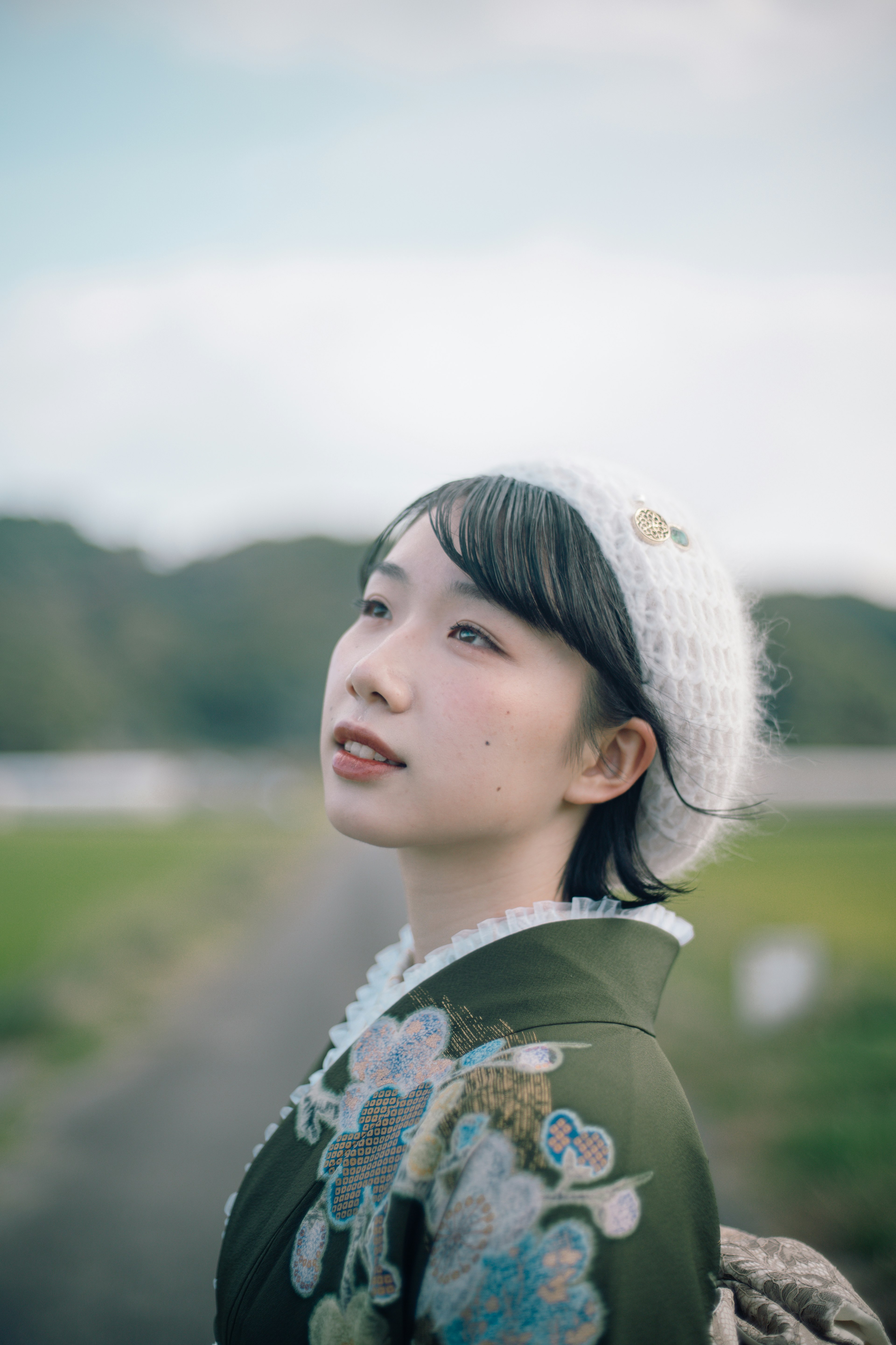 Une femme en kimono vert regardant le ciel