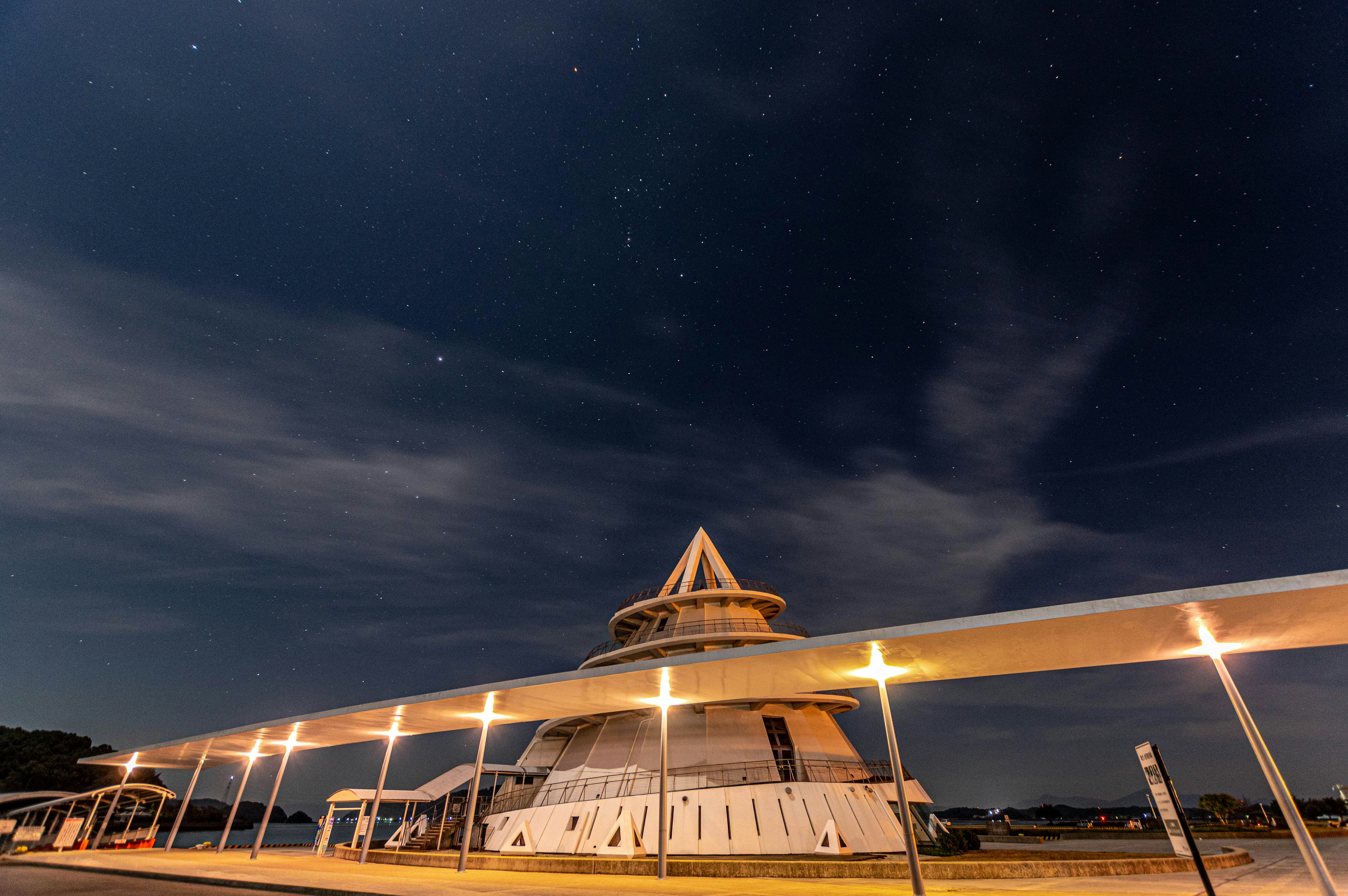 Struttura architettonica unica illuminata di notte sotto un cielo stellato