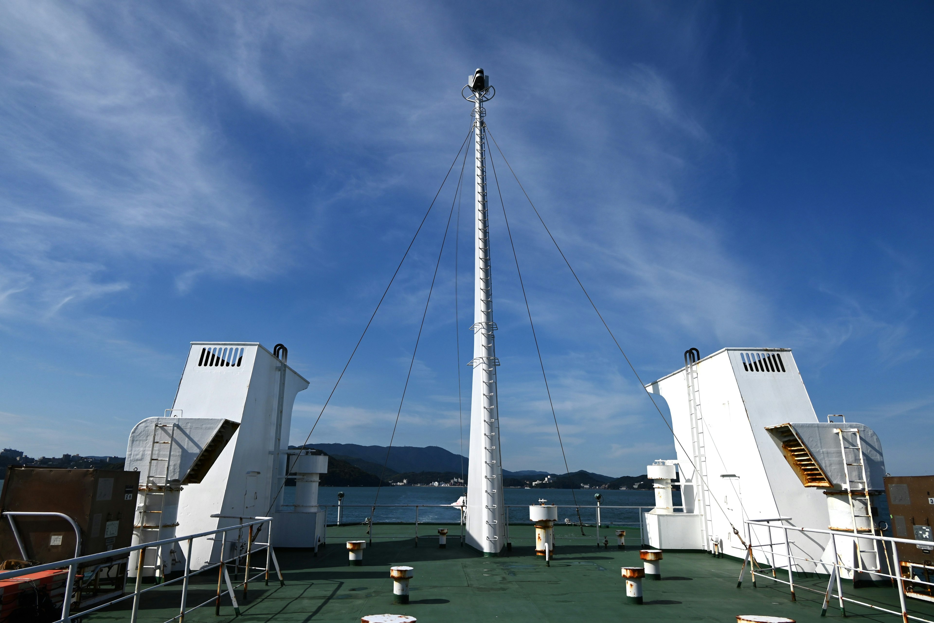 Deck eines Schiffes mit einem hohen Mast unter einem blauen Himmel