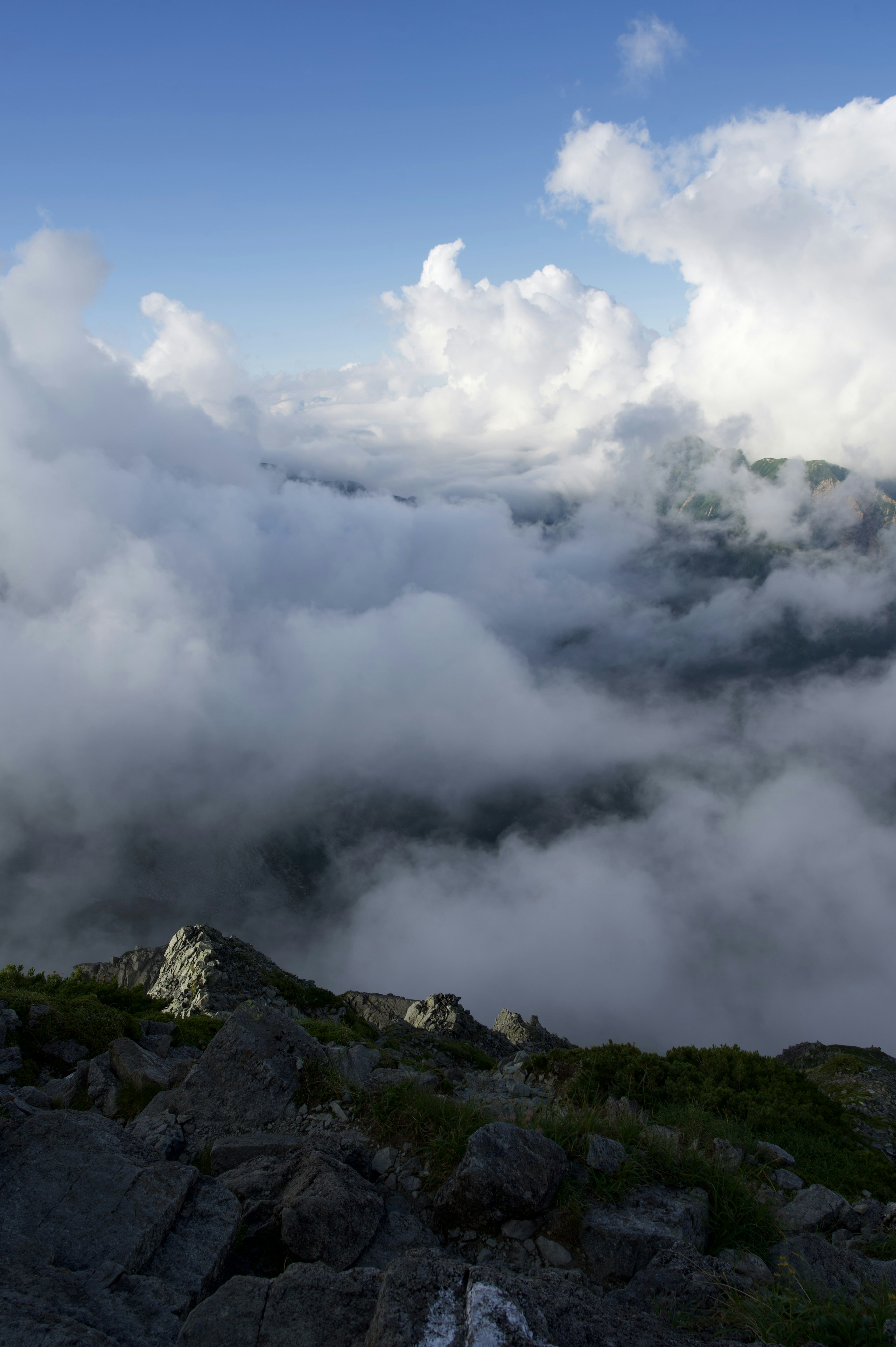 Paesaggio montano sopra le nuvole con cielo blu