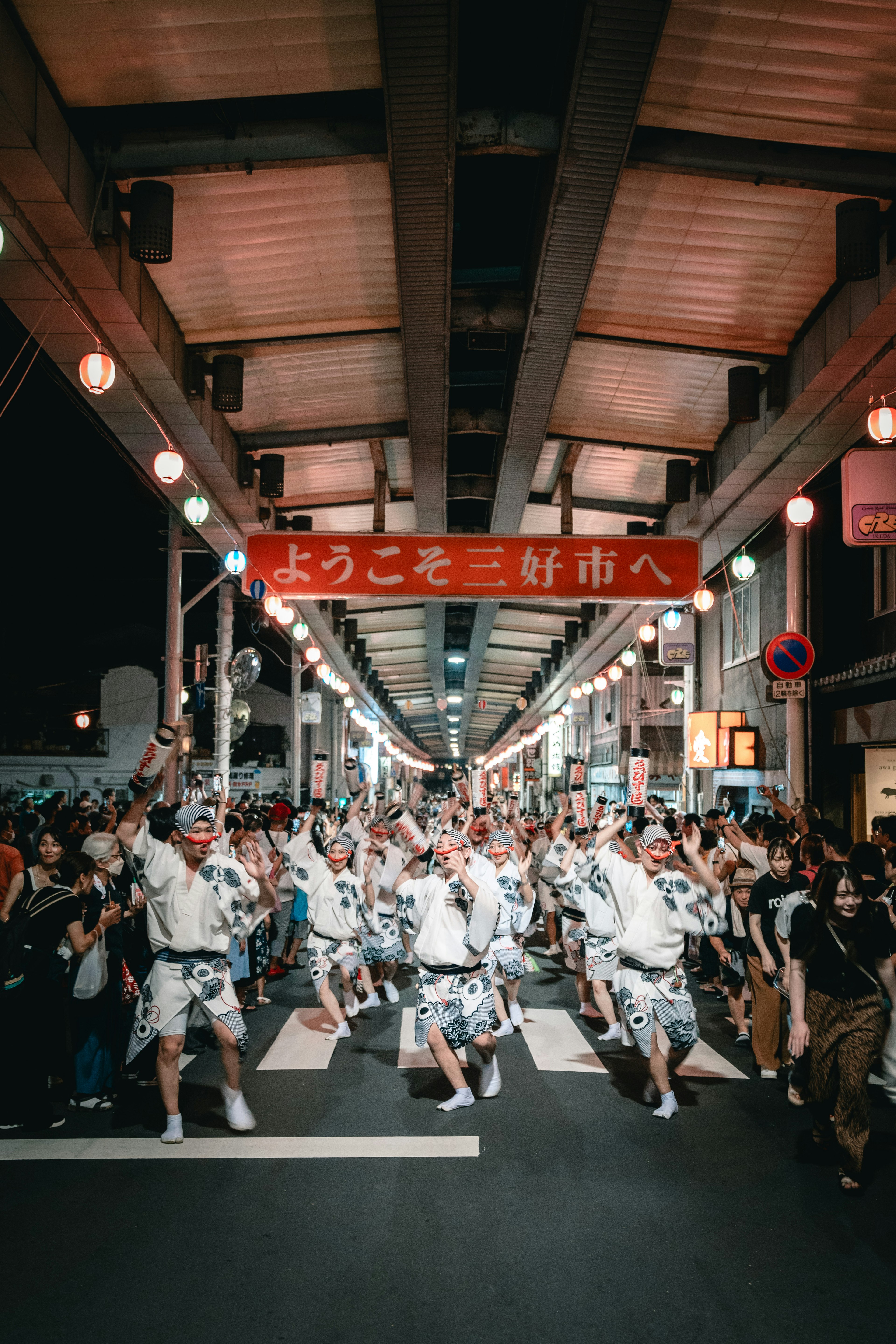 Folla di persone che celebrano un festival di notte in una strada vivace