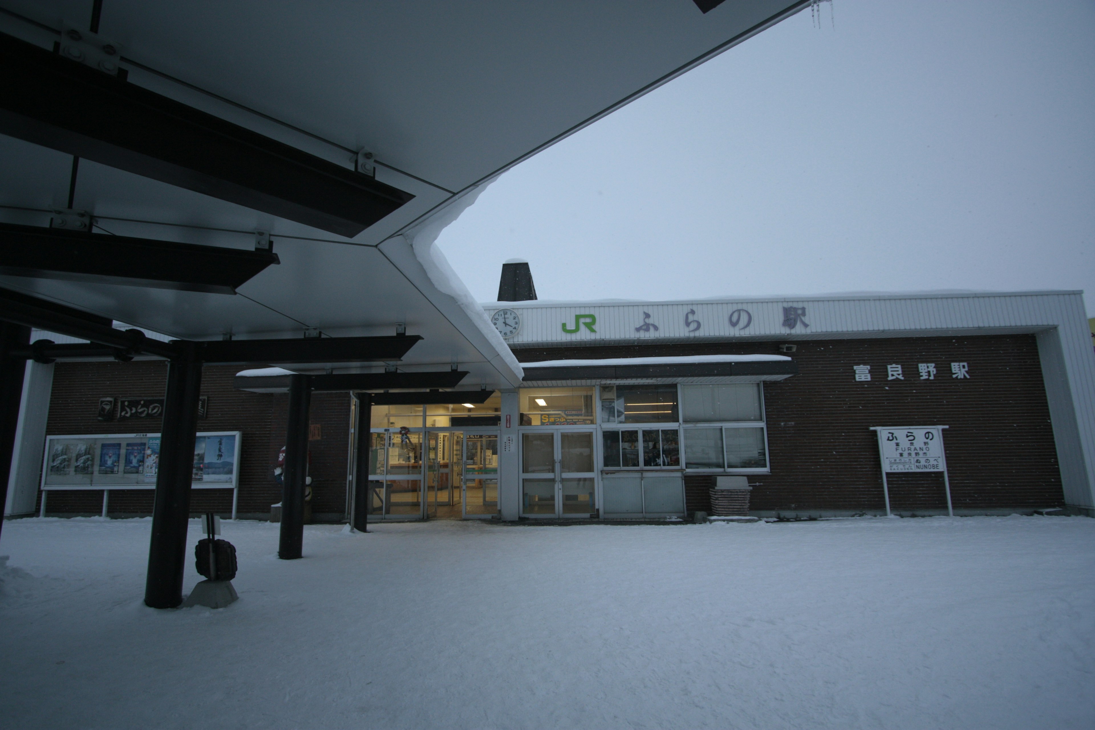 Vista esterna di una stazione ferroviaria coperta di neve in inverno