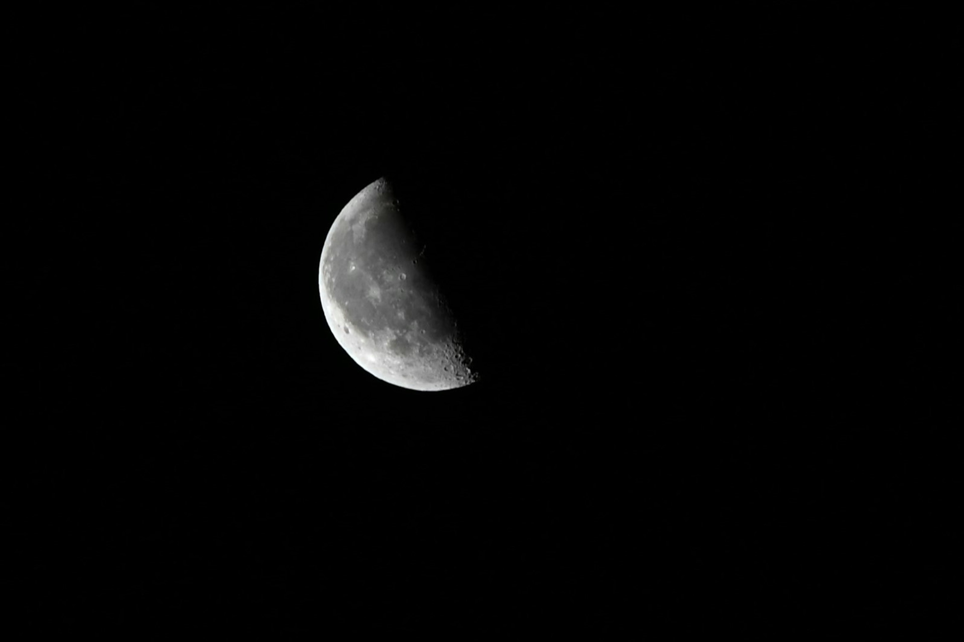 Media luna visible contra un cielo oscuro