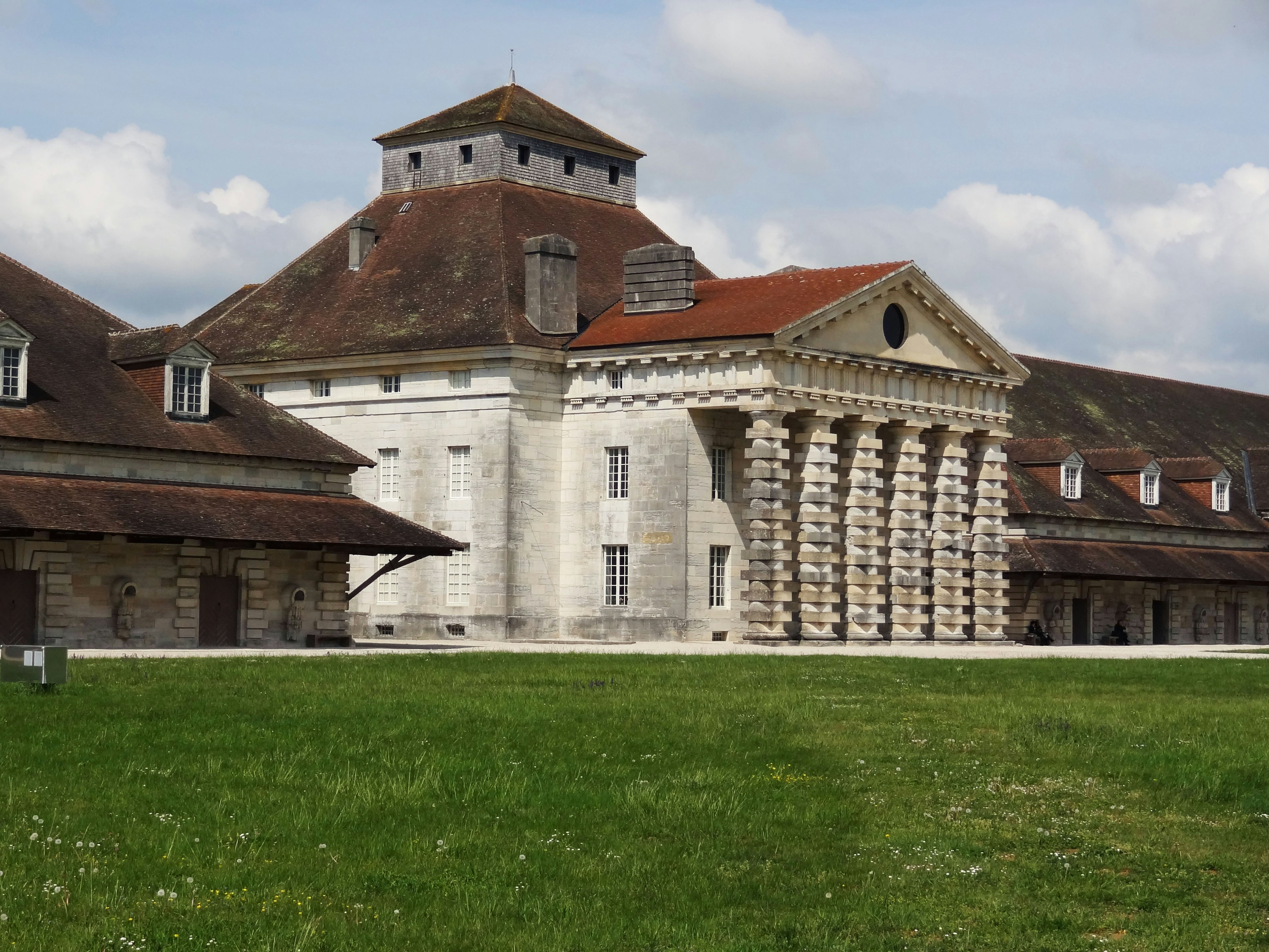 Bâtiment historique avec des caractéristiques architecturales uniques et une herbe verte