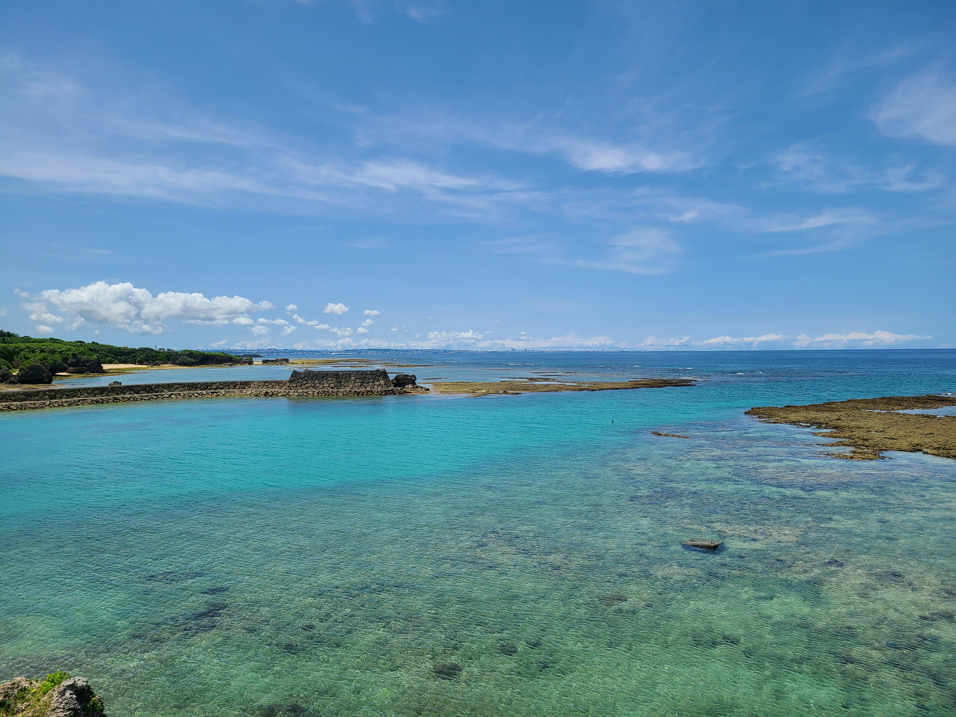 Pemandangan laut dan langit biru air jernih dan terumbu yang terlihat