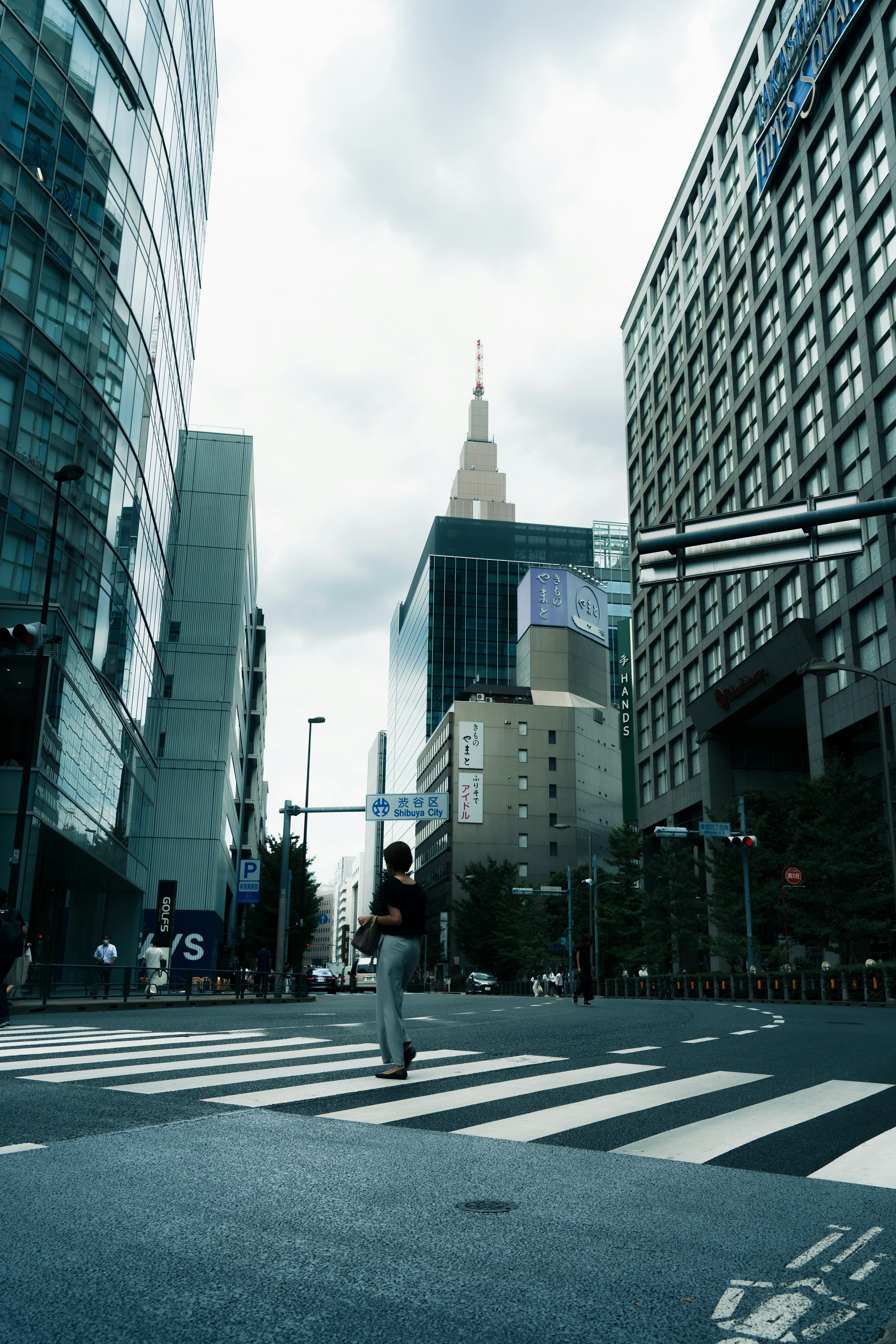 交差点で歩いている人物と高層ビルの風景