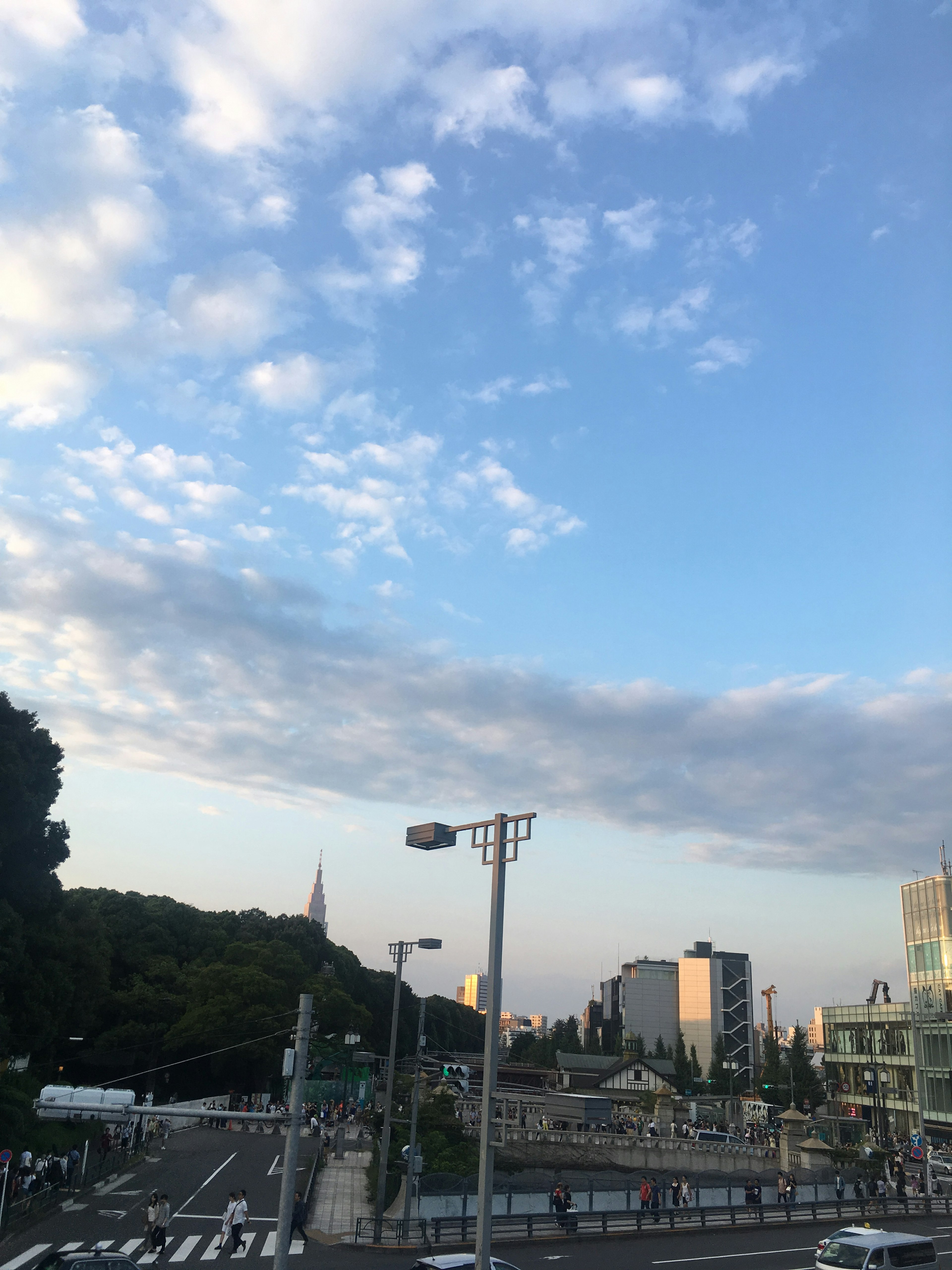 Tokyoter Landschaft mit blauem Himmel und Wolken sowie einer Kreuzung mit Gebäuden