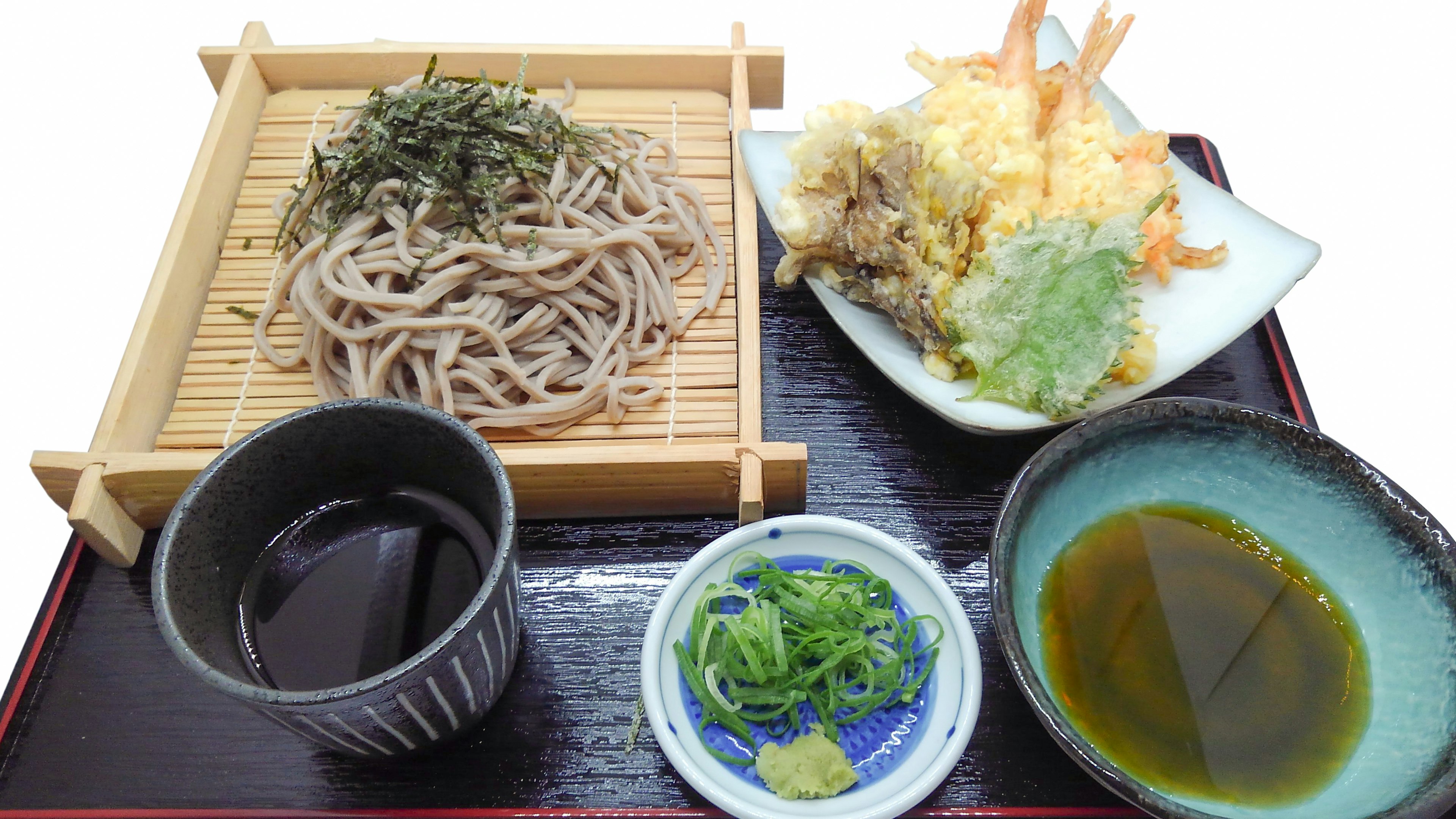 A plate of soba noodles with tempura and dipping sauce