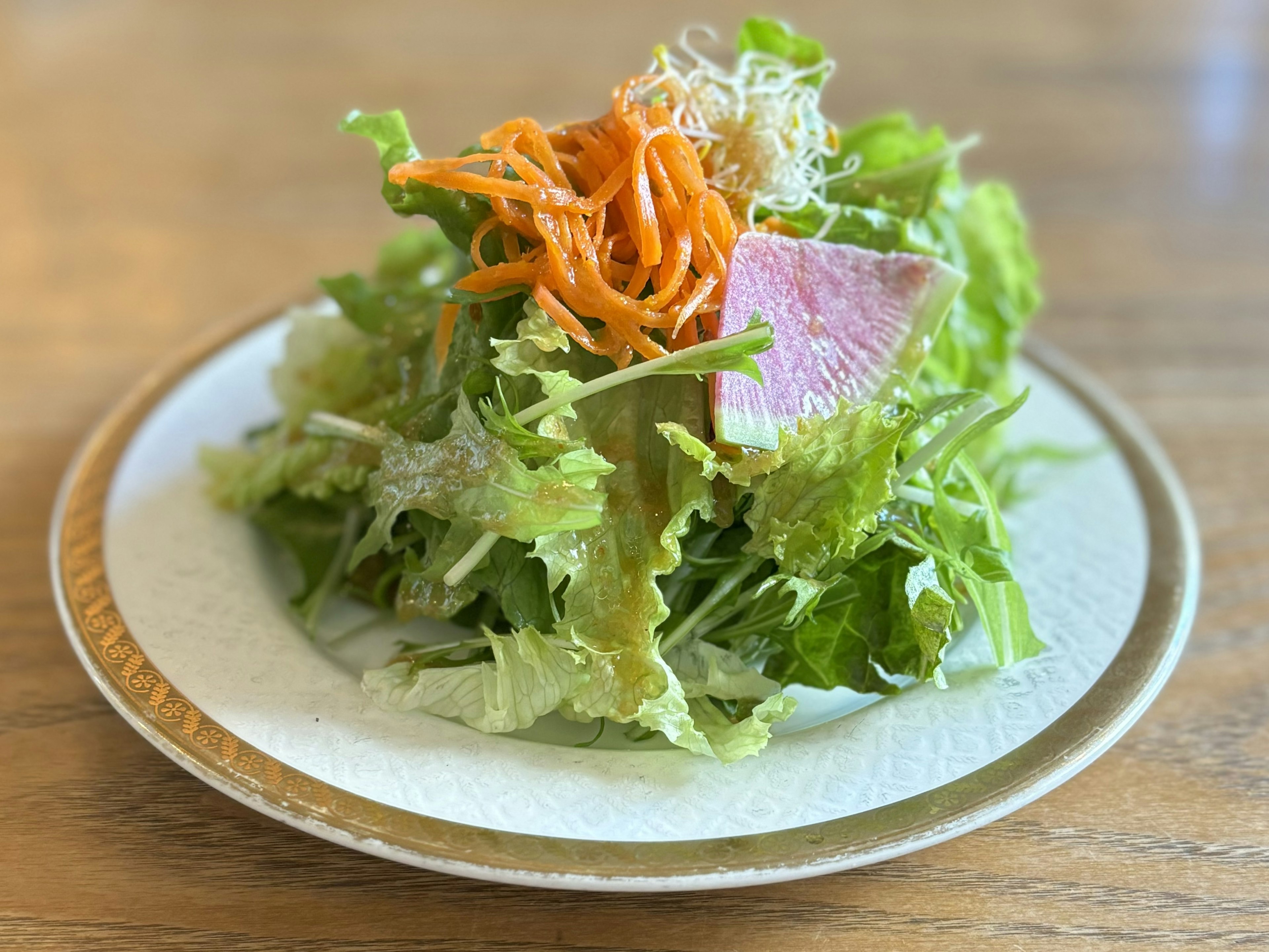 Une assiette de salade de laitue et de carottes fraîches garnie de tranches de jambon