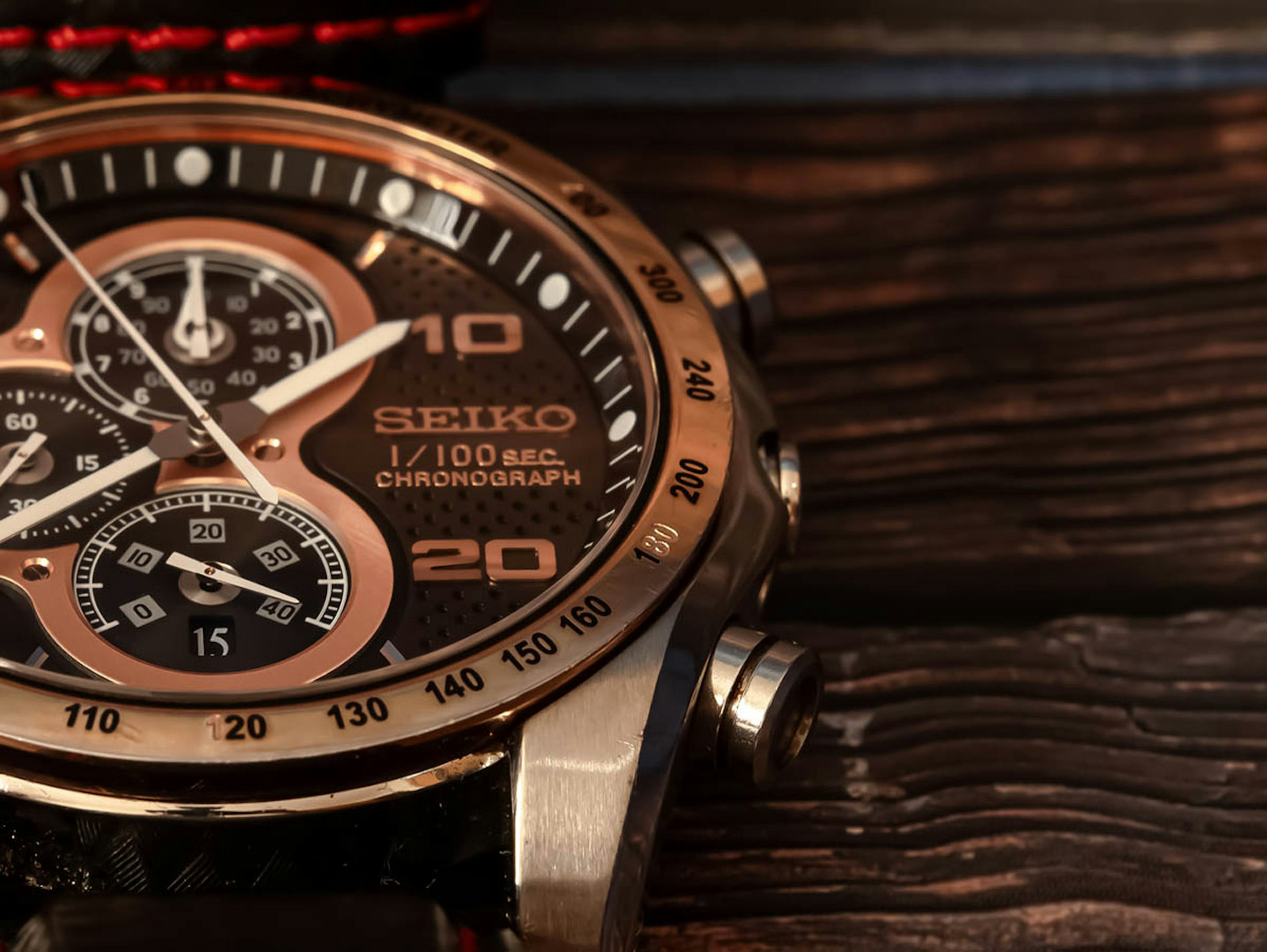 Close-up of a Seiko chronograph watch with a black dial and gold accents on a wooden background