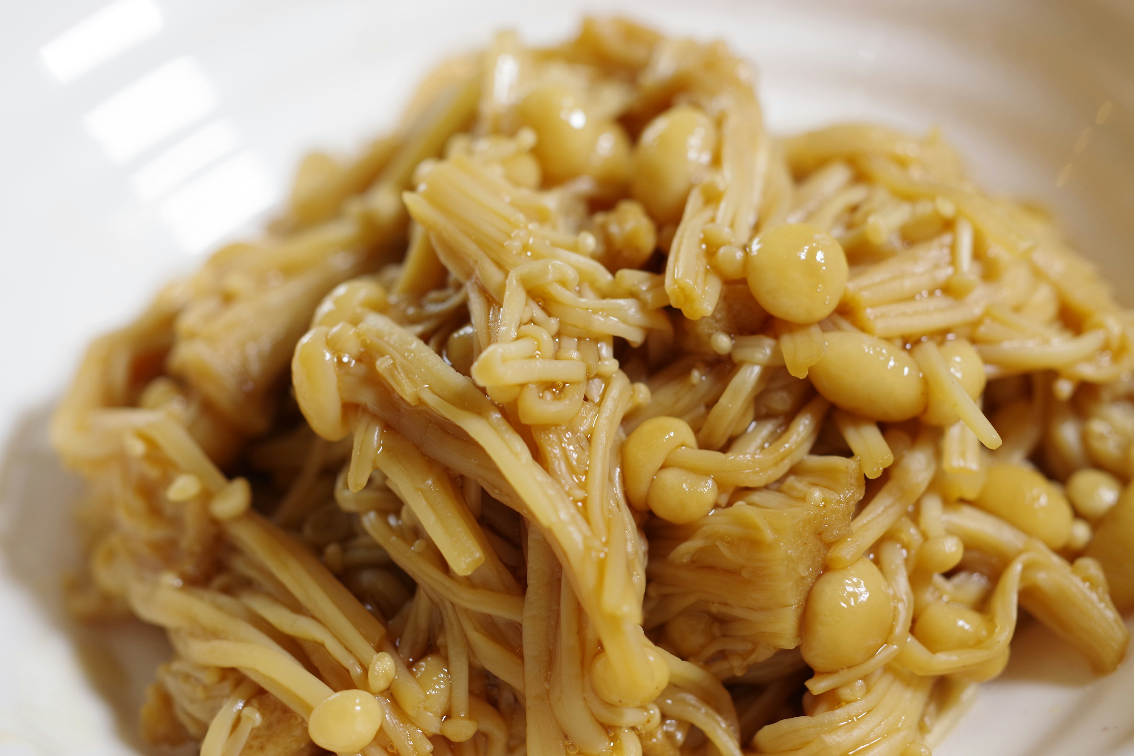 Cooked enoki mushrooms served in a white bowl