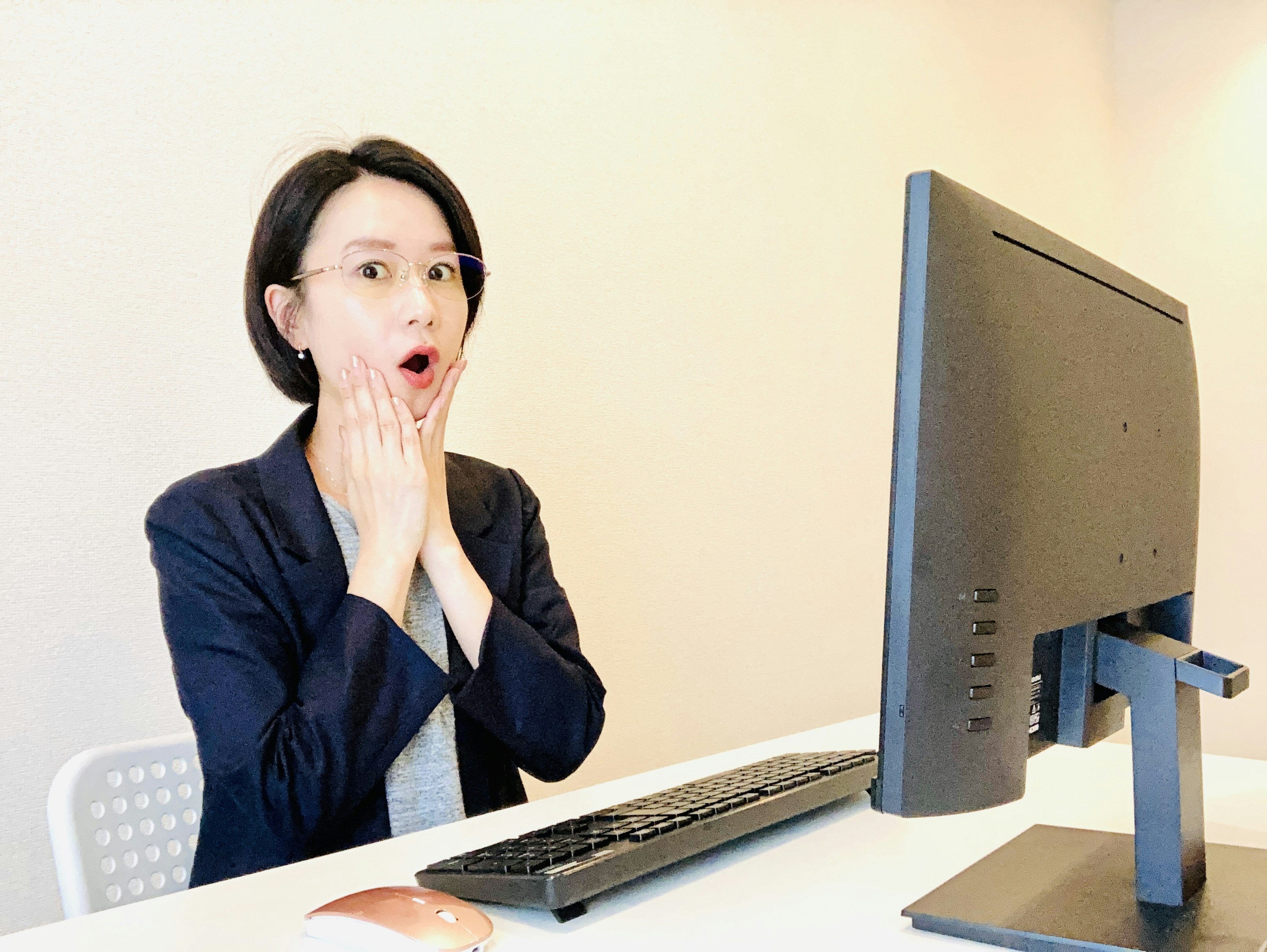 Une femme surprise assise devant un ordinateur