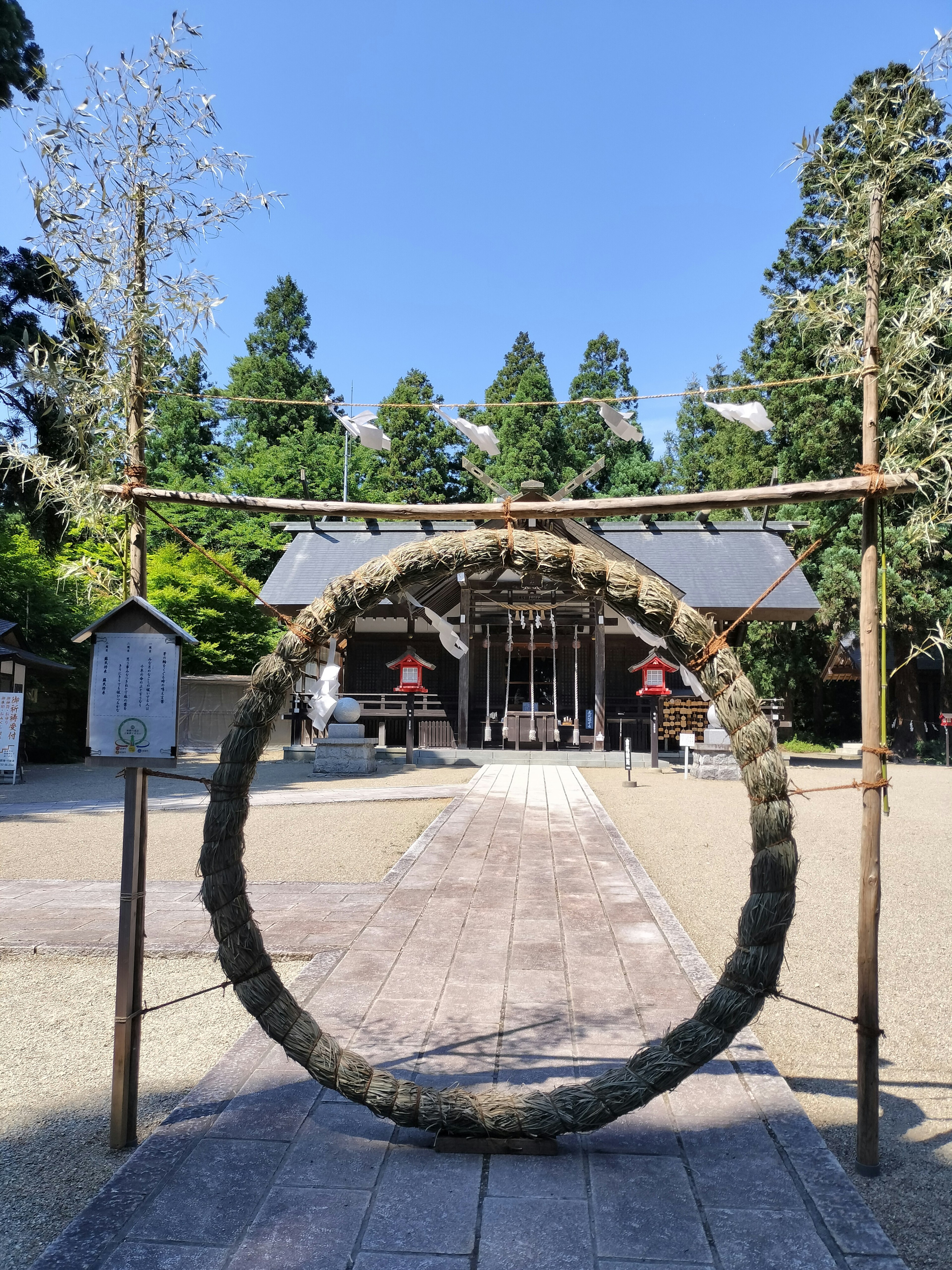 神社の前にある大きな輪と緑の木々