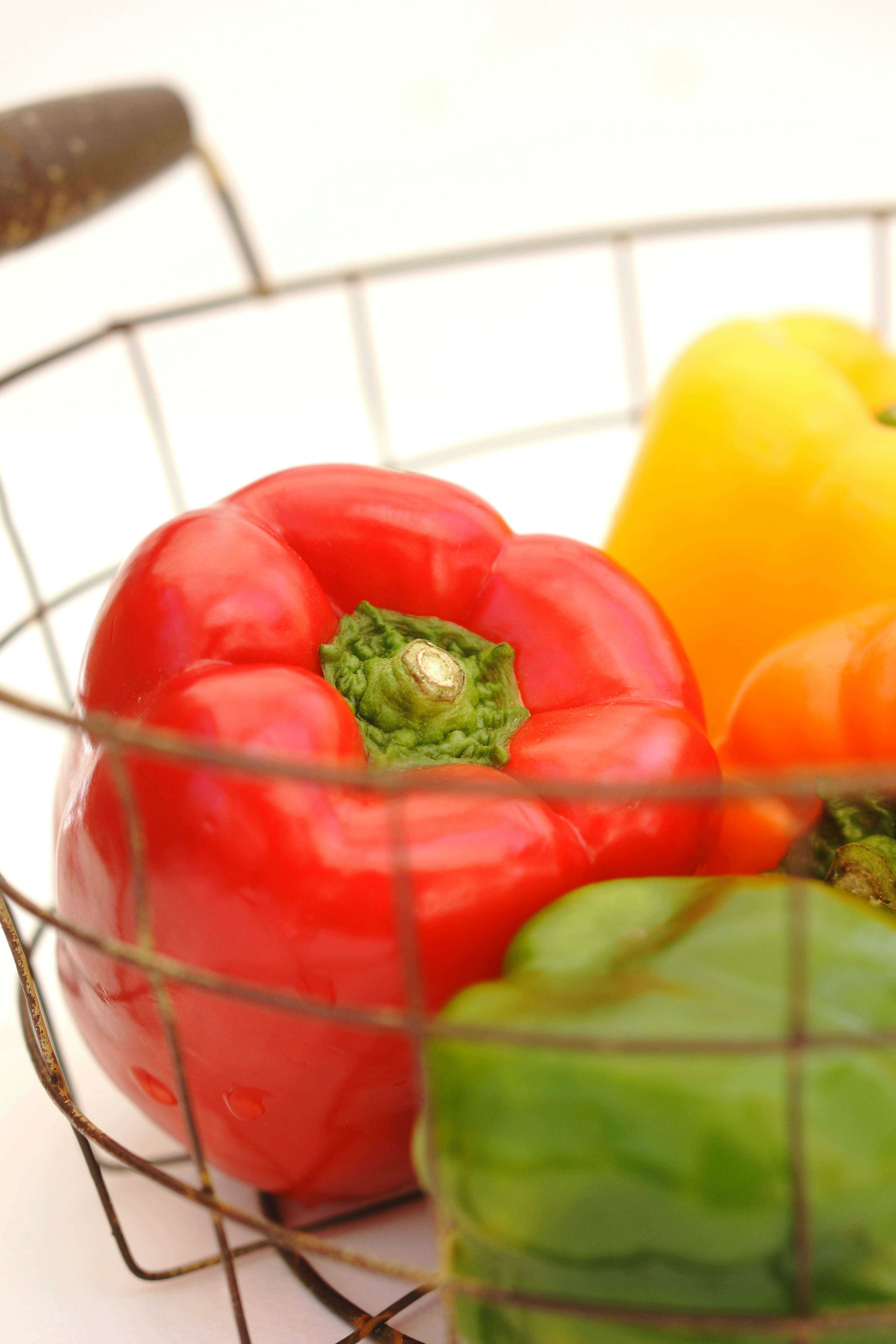 Poivrons colorés dans un panier en fil métallique