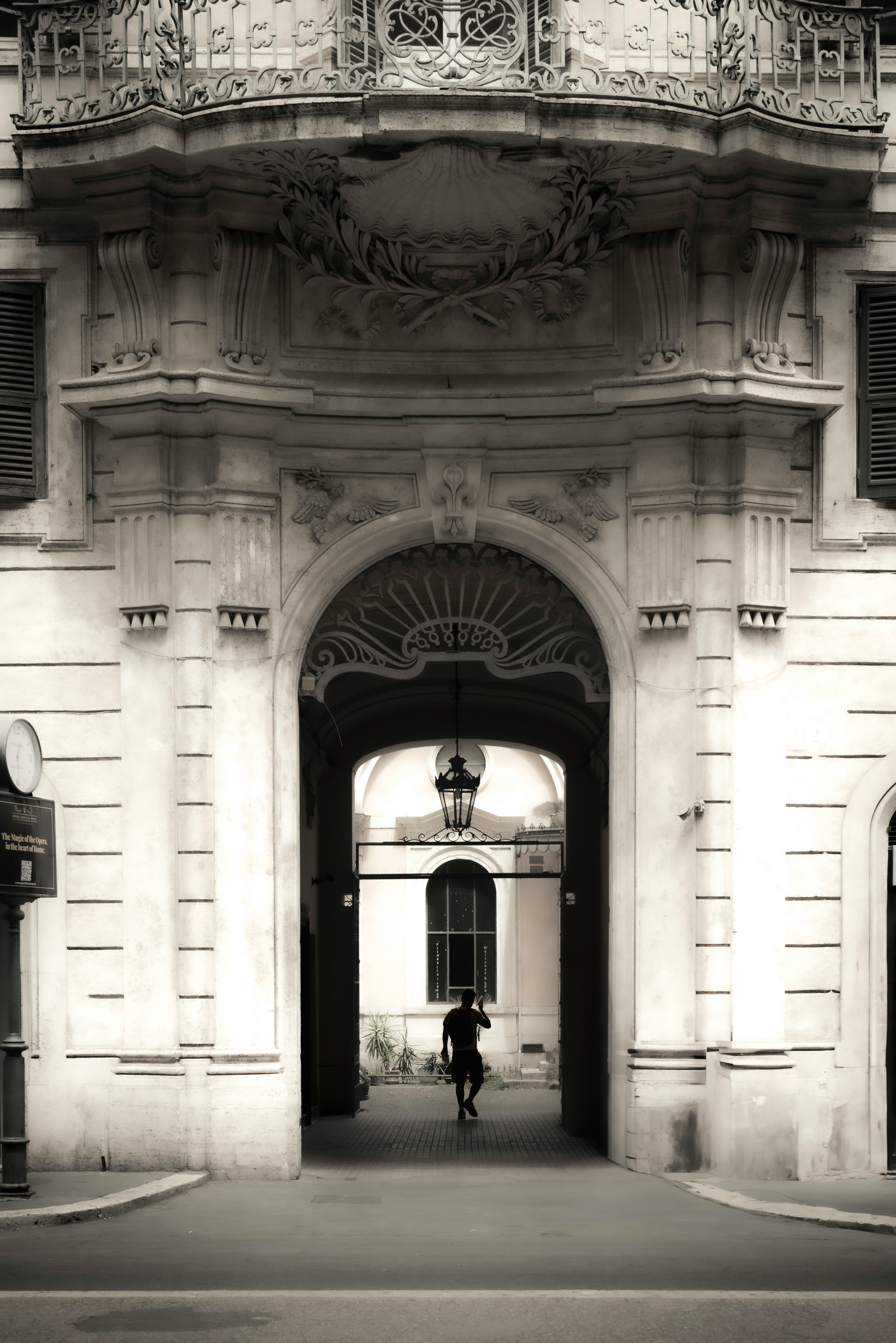 A person walking through an archway of a building with intricate details