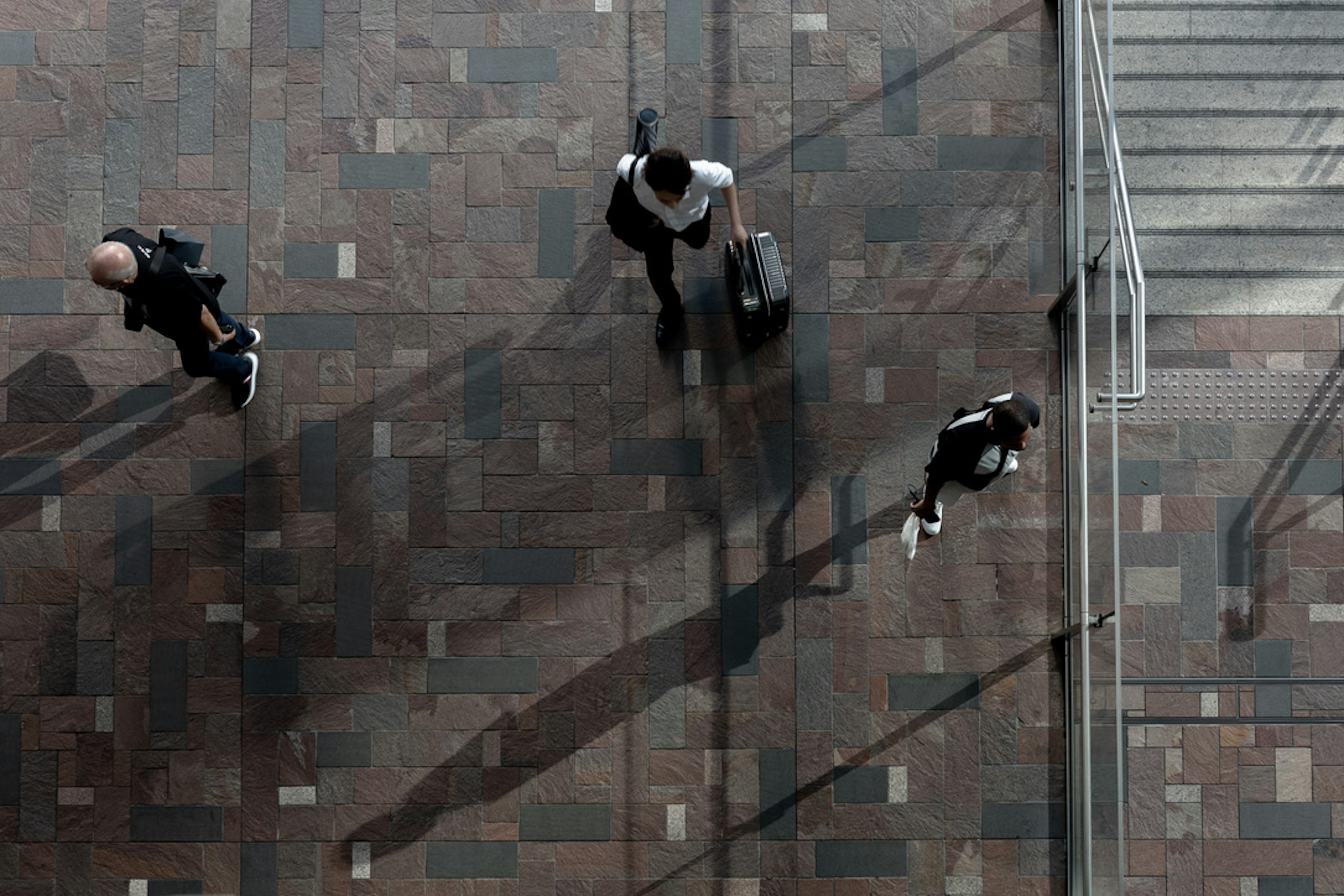 Vista aérea de personas caminando en el vestíbulo de un edificio comercial con sombras