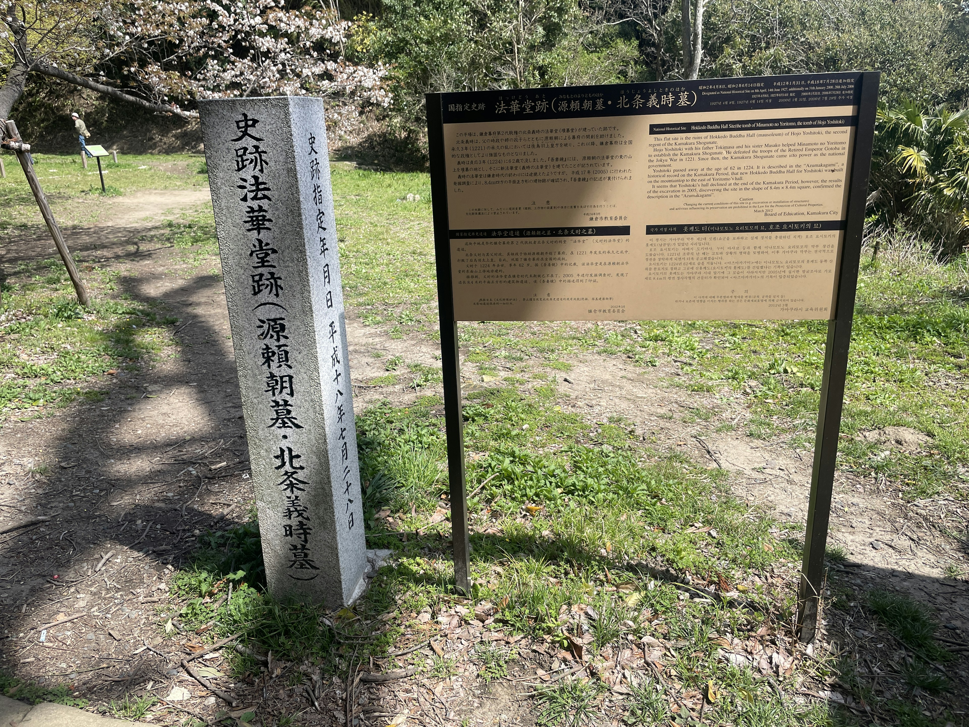 Immagine di un monumento in pietra e di un pannello informativo all'ingresso di un parco