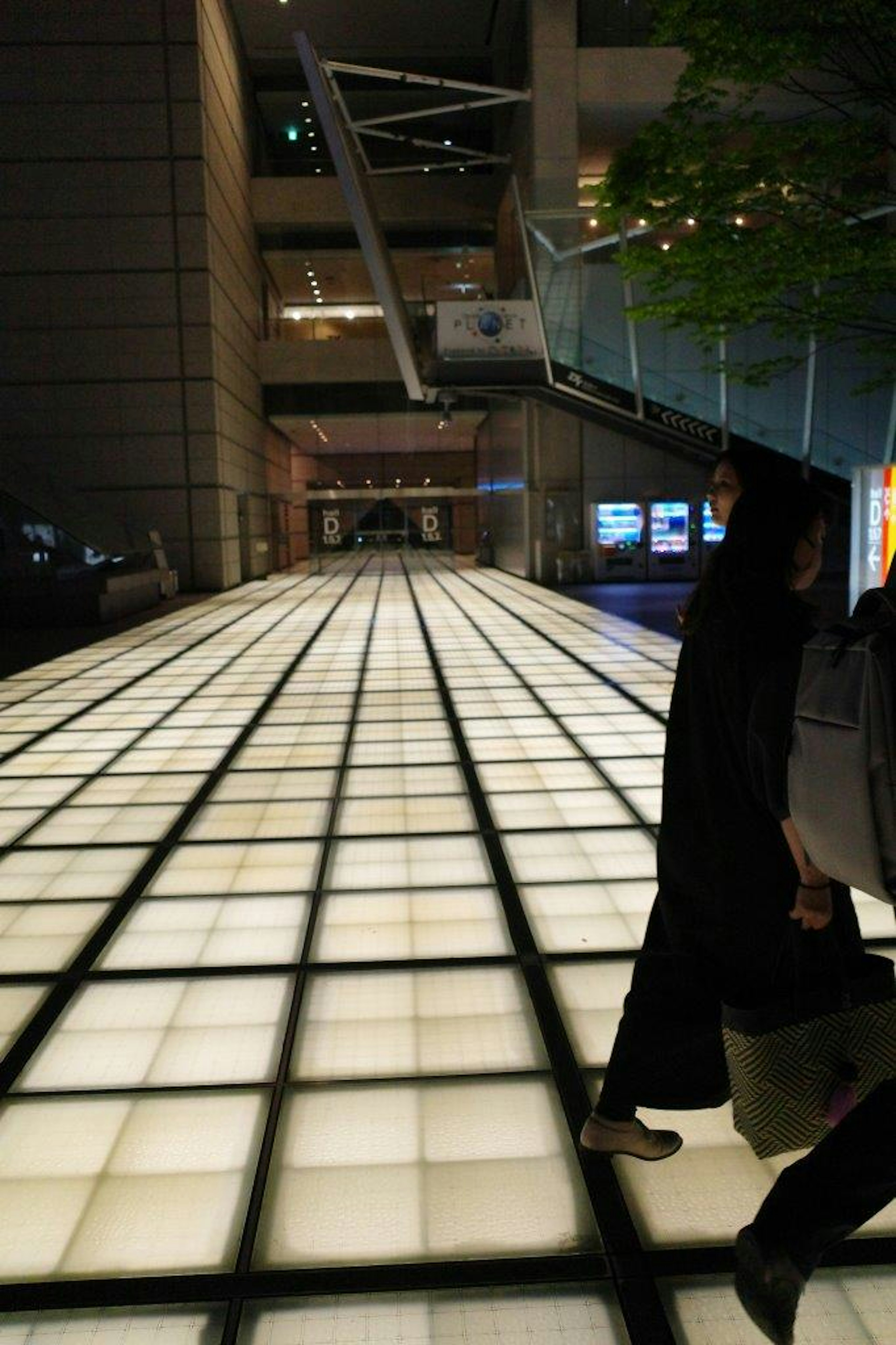 Interno moderno con pavimento luminoso e persone che camminano