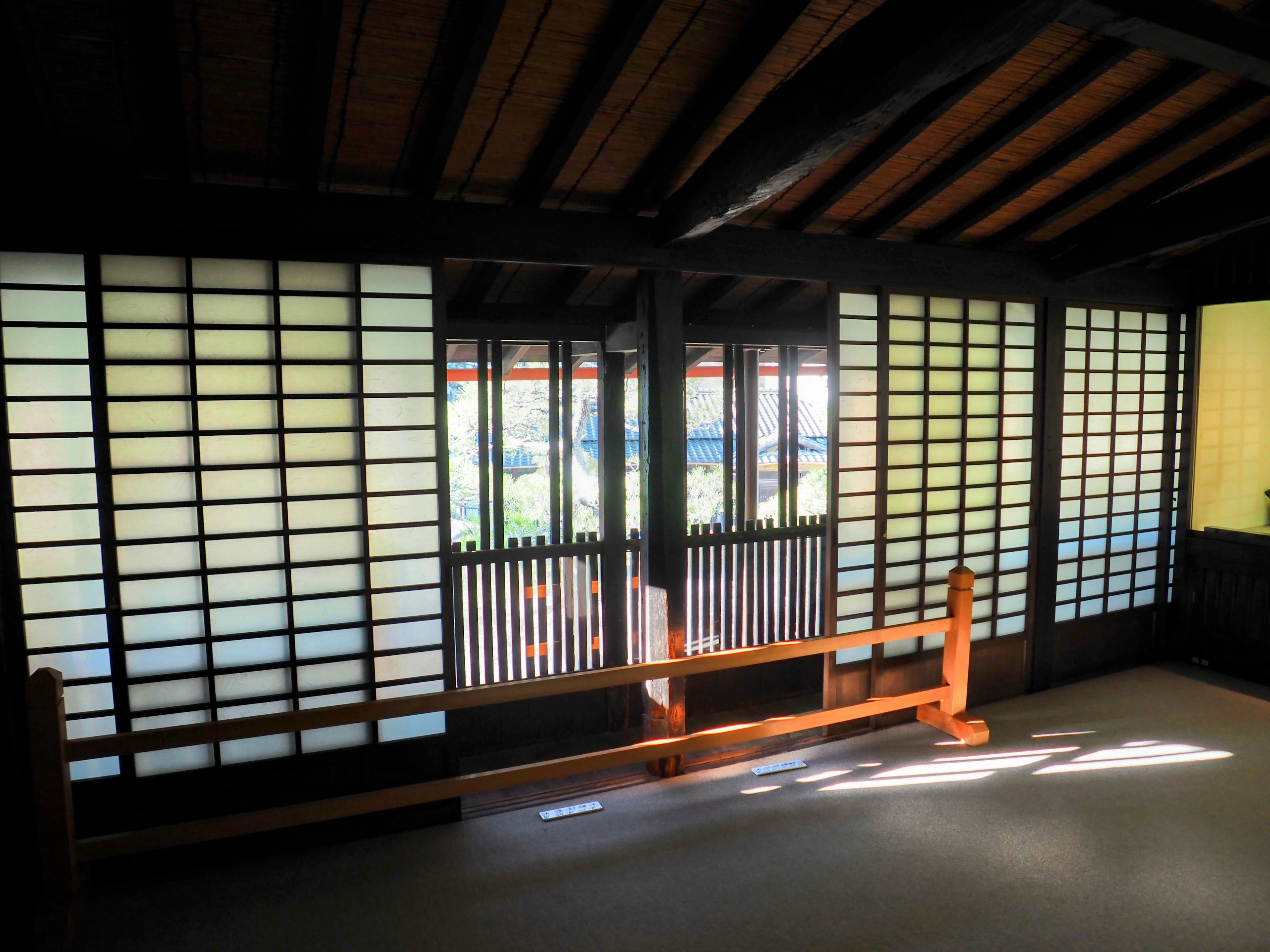 Intérieur d'un bâtiment japonais traditionnel avec des fenêtres shoji des poutres en bois et une atmosphère chaleureuse