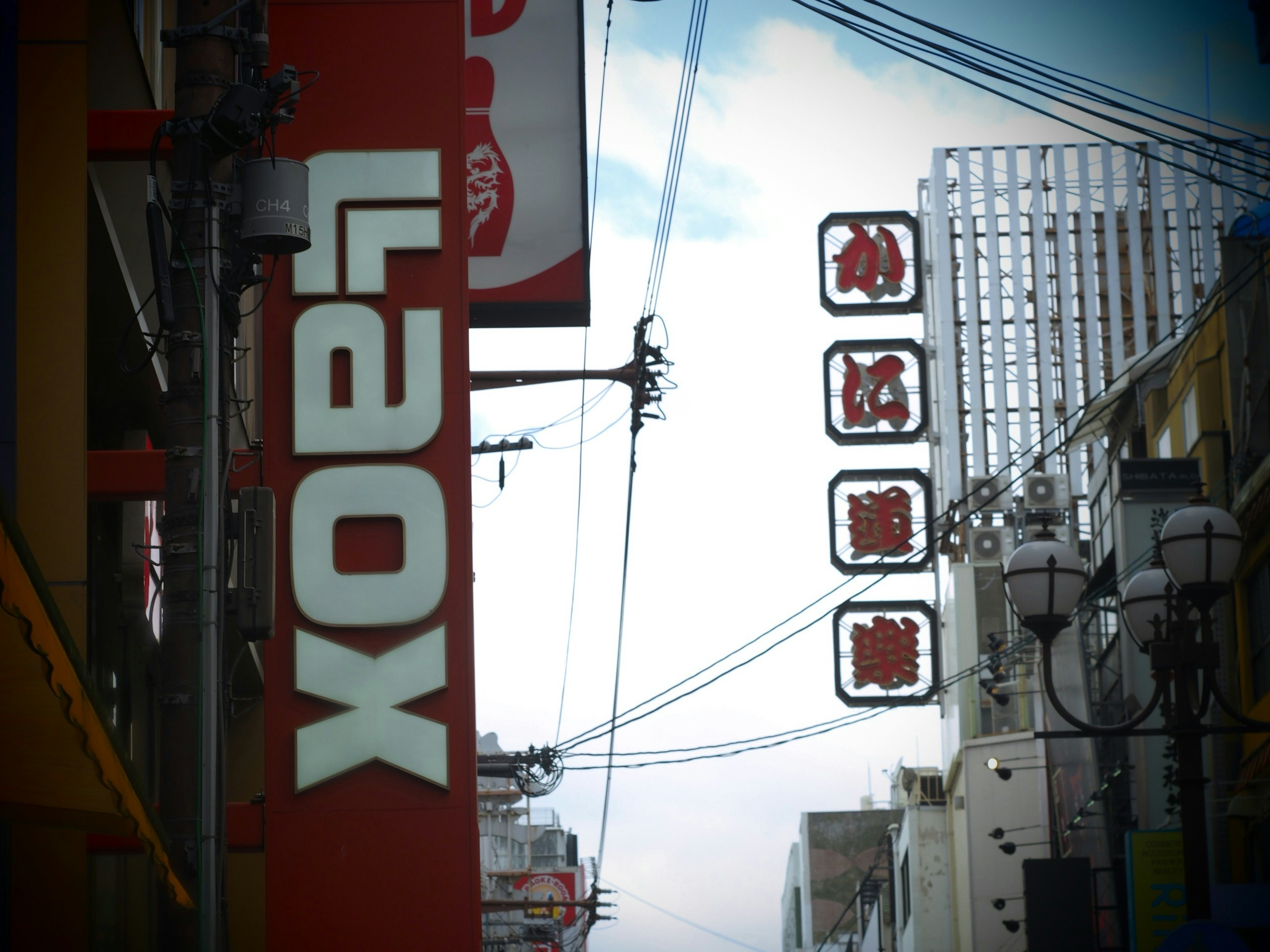 Street view featuring a red Laox sign with white lettering and visible power lines