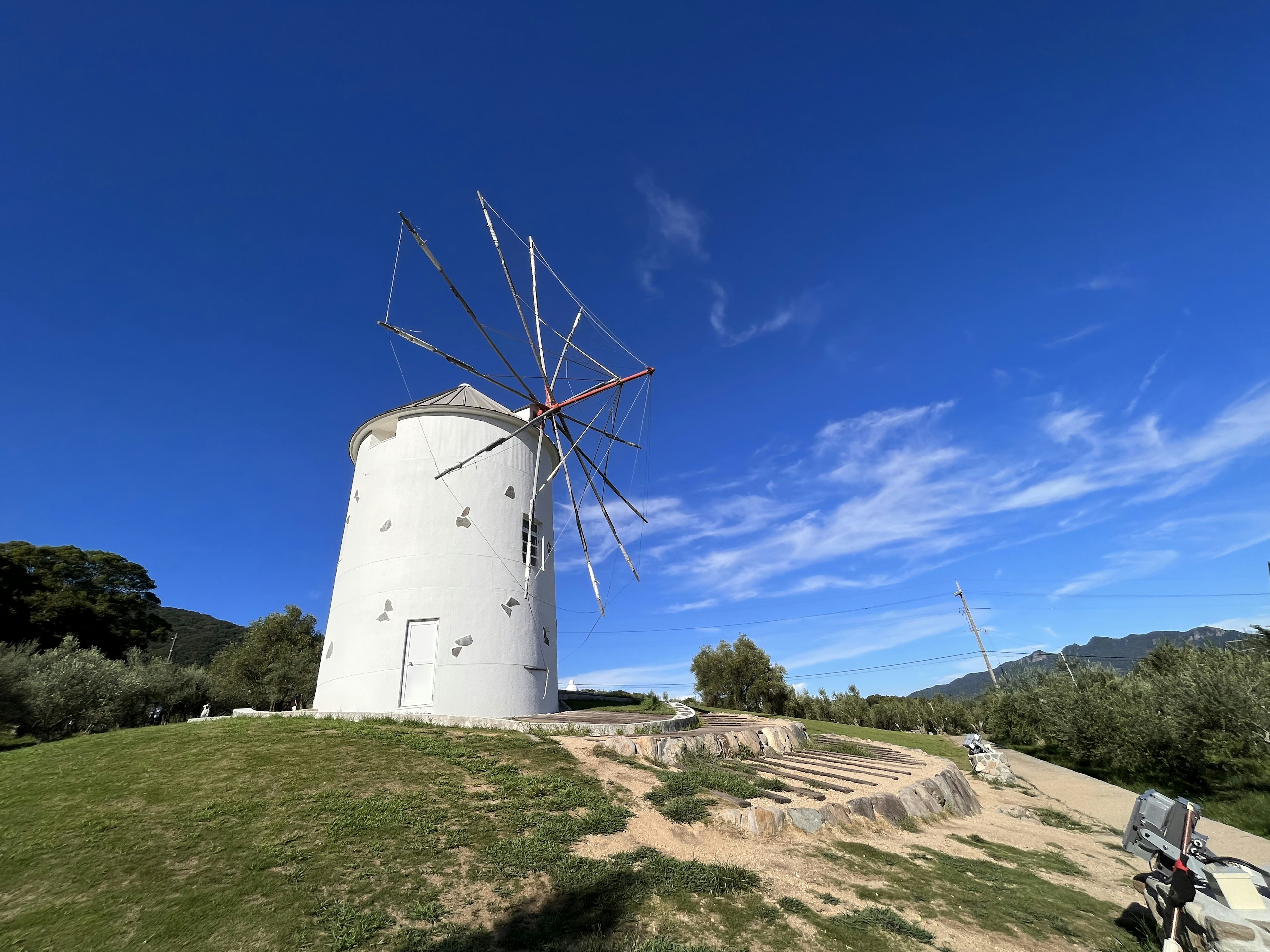 Paisaje con un molino de viento bajo un hermoso cielo azul