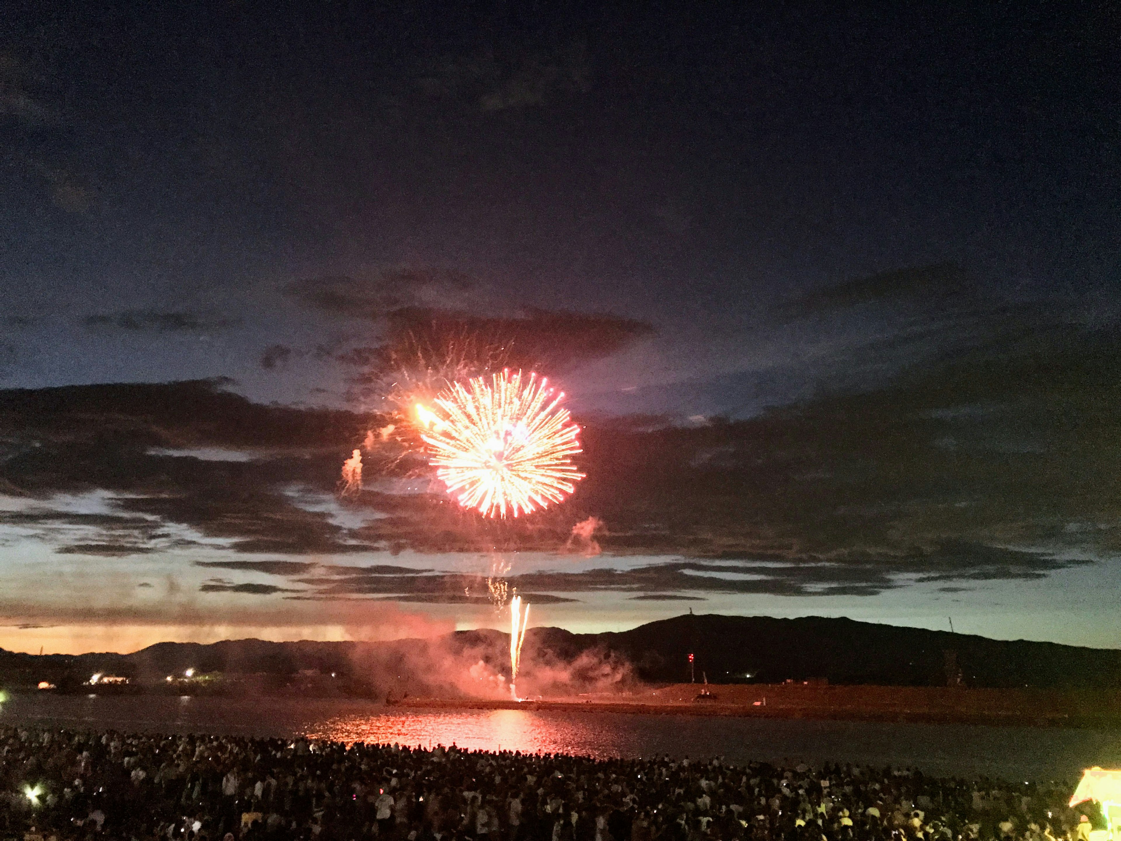 Feuerwerk, das am Nachthimmel platzt, während eine Menge zusieht