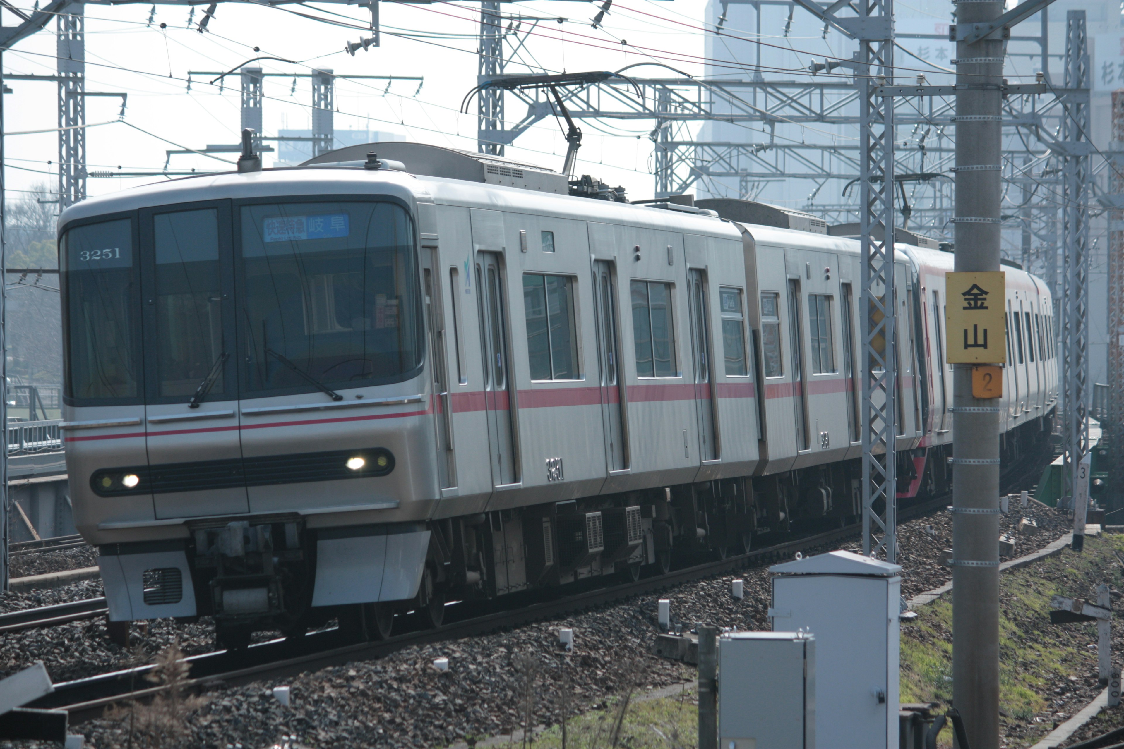 Train running on railway tracks with a white and red design