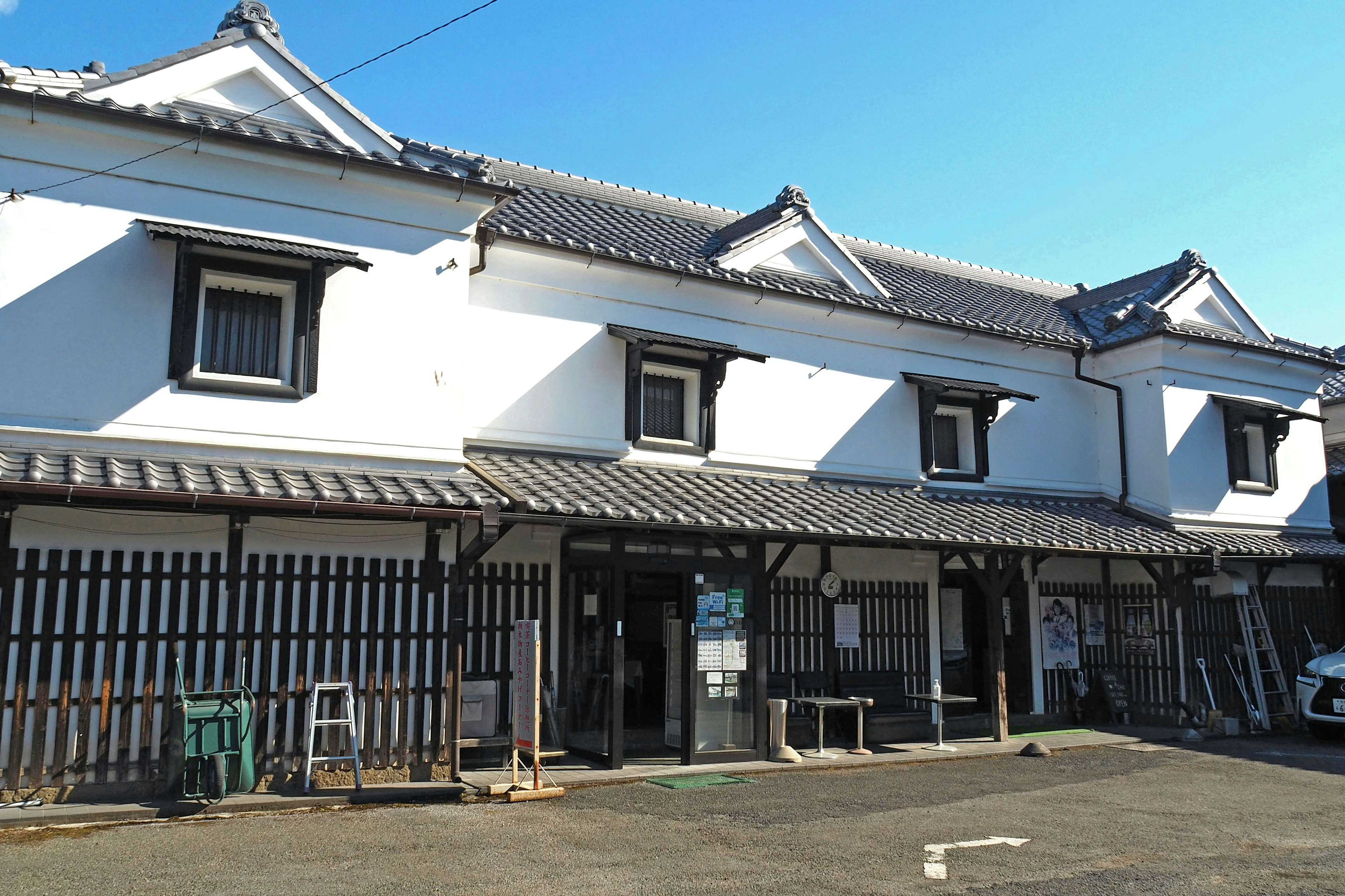 Bâtiment japonais traditionnel avec des murs blancs et un balcon en bois noir