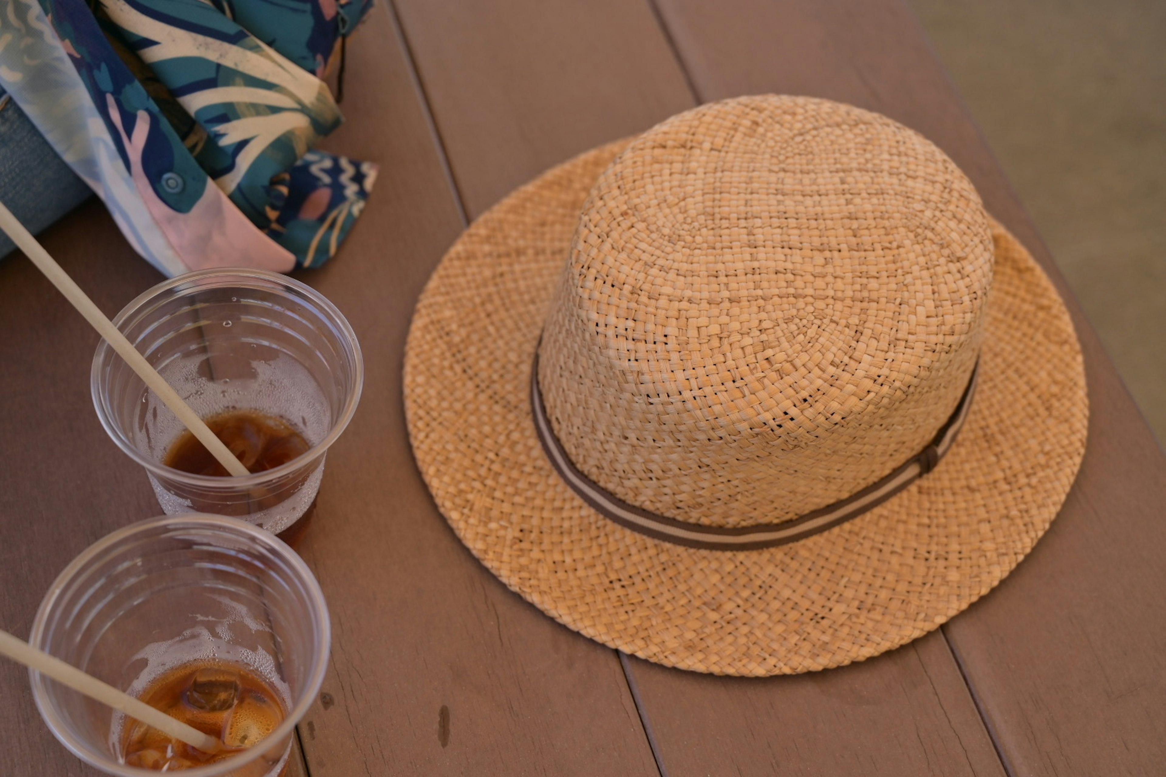 Un cappello di paglia posato su un tavolo accanto a due bevande