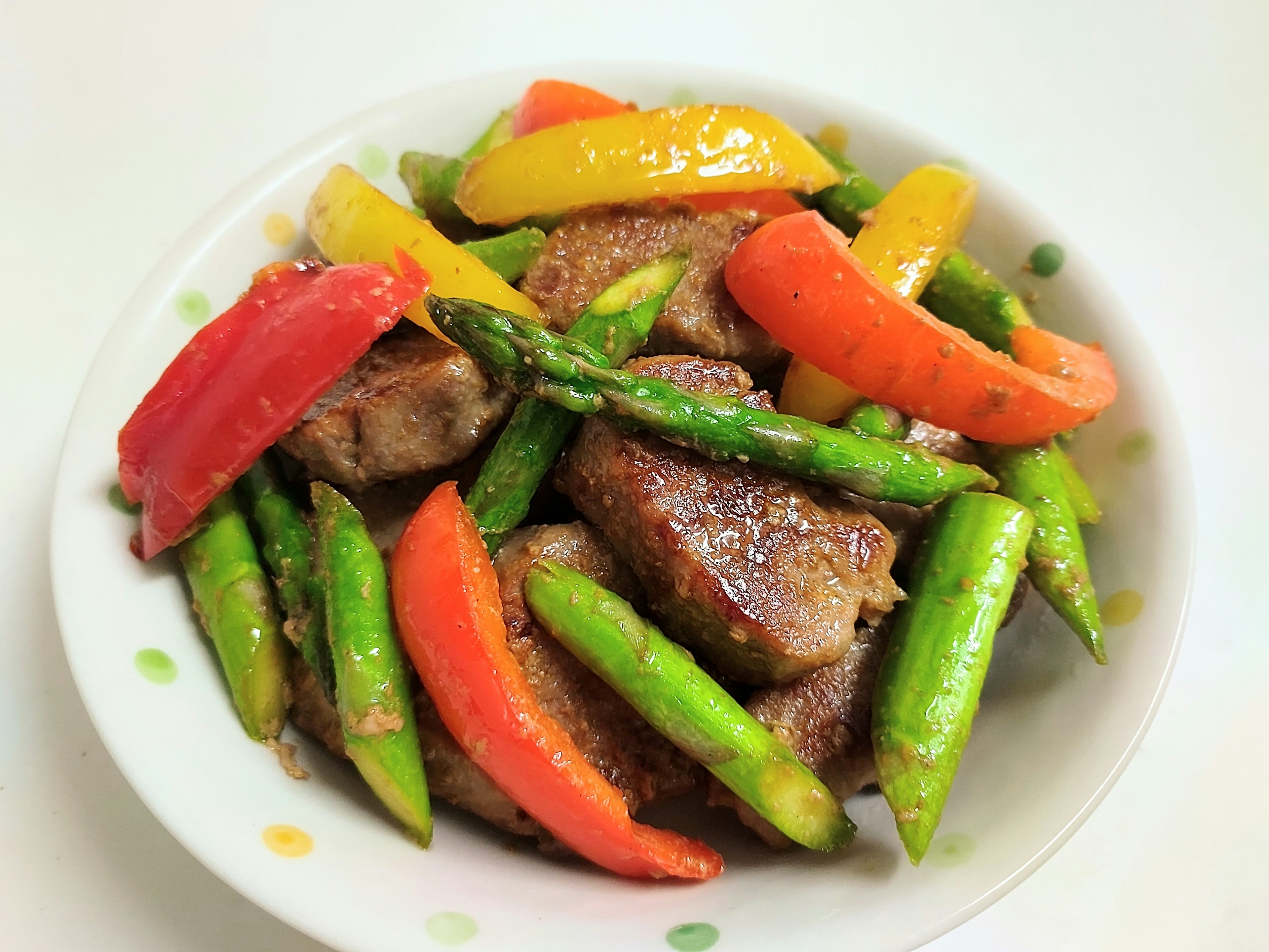 Stir-fried colorful vegetables and meat served in a white bowl