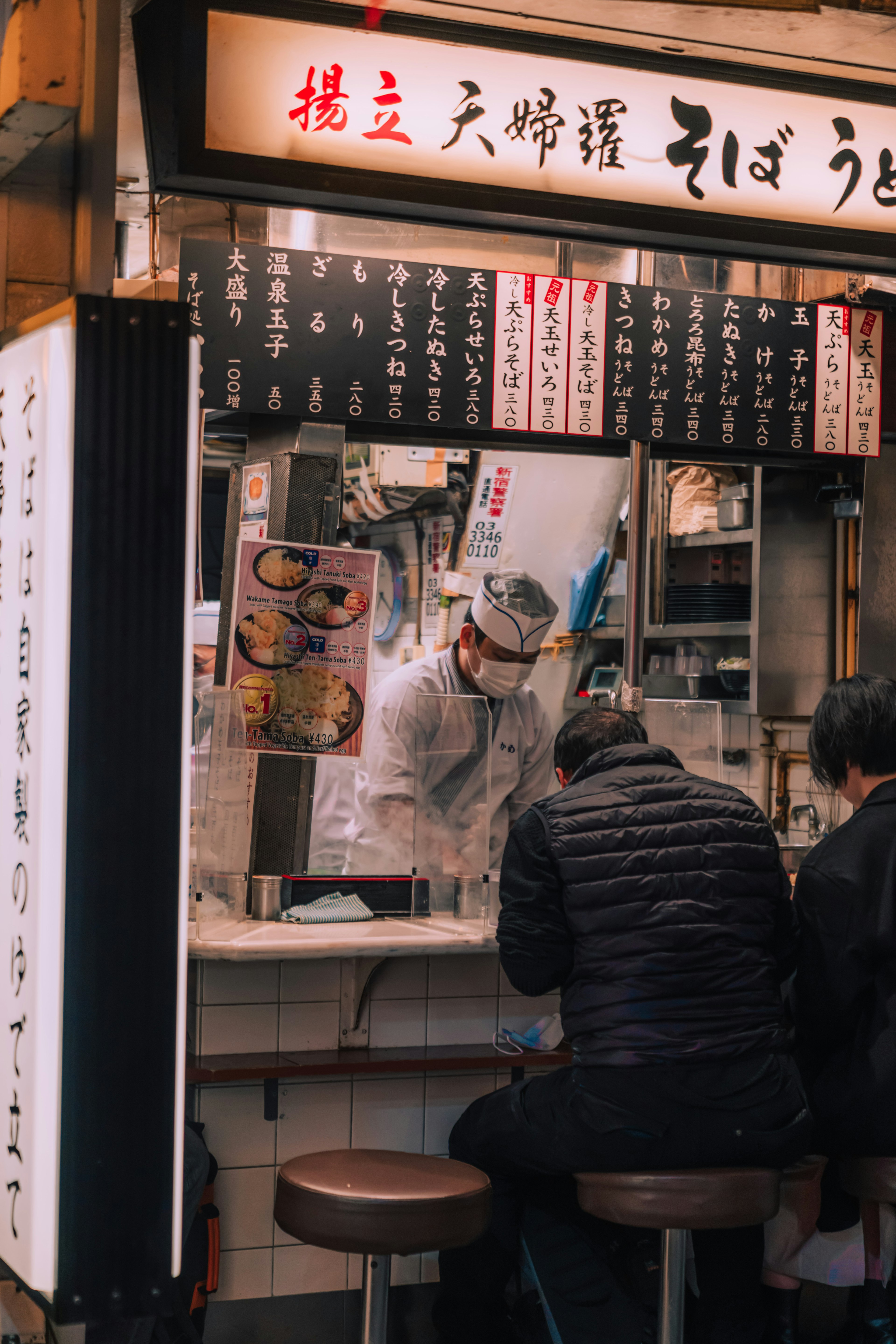 日本の屋台でそばを作る料理人と客