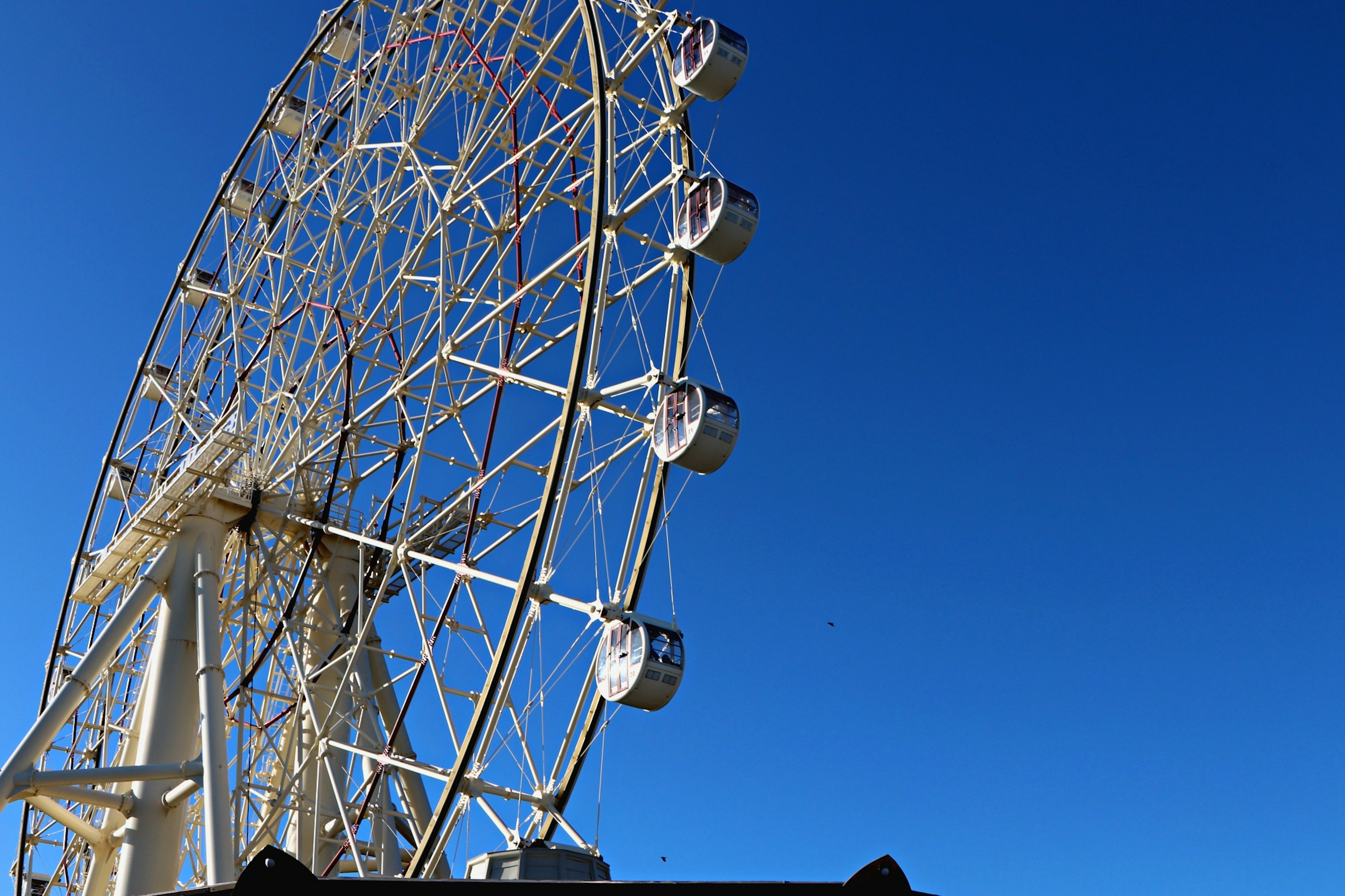 Vista laterale di una ruota panoramica contro un cielo blu