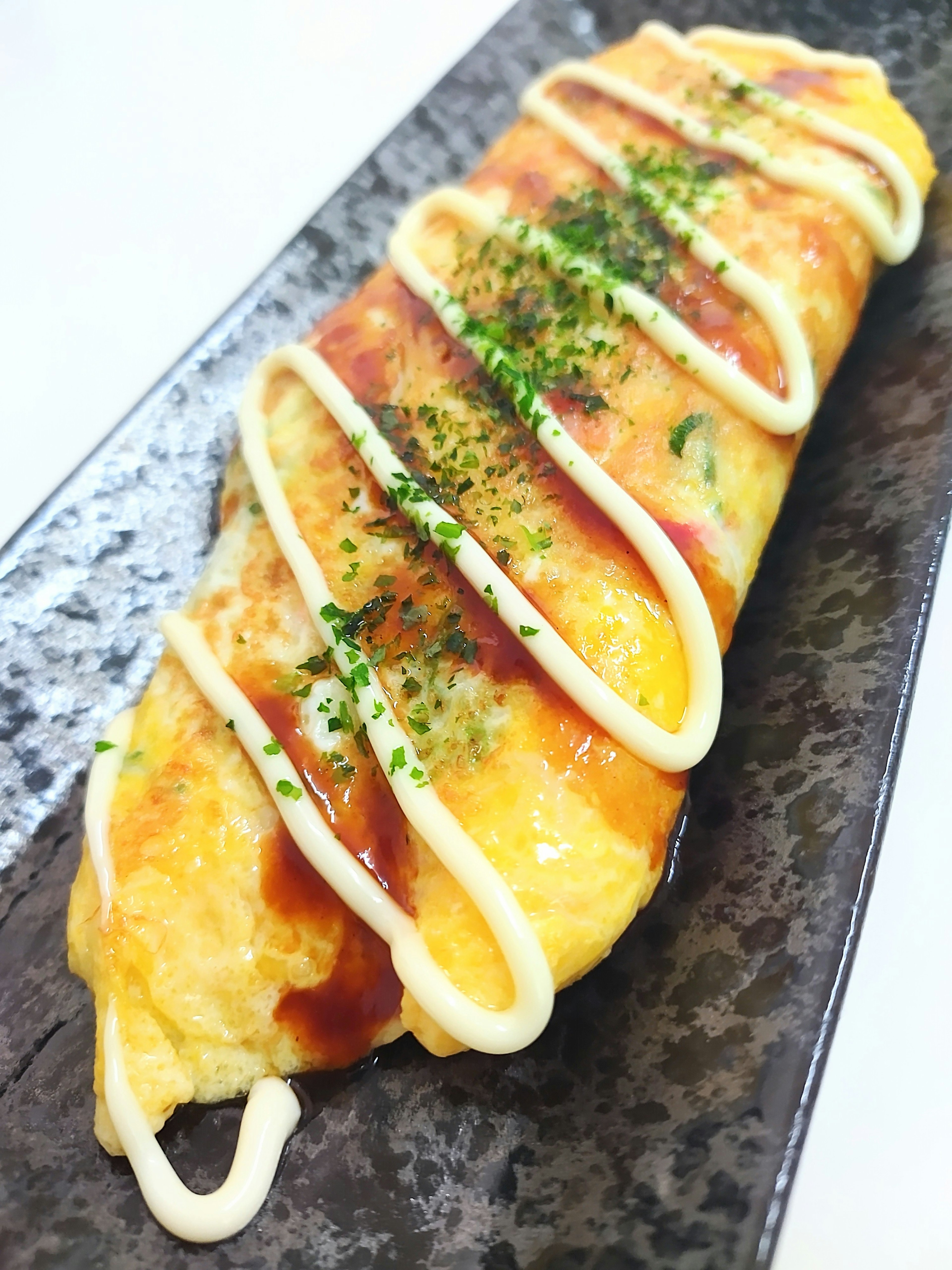 Omelette de riz délicieuse servie sur une assiette noire