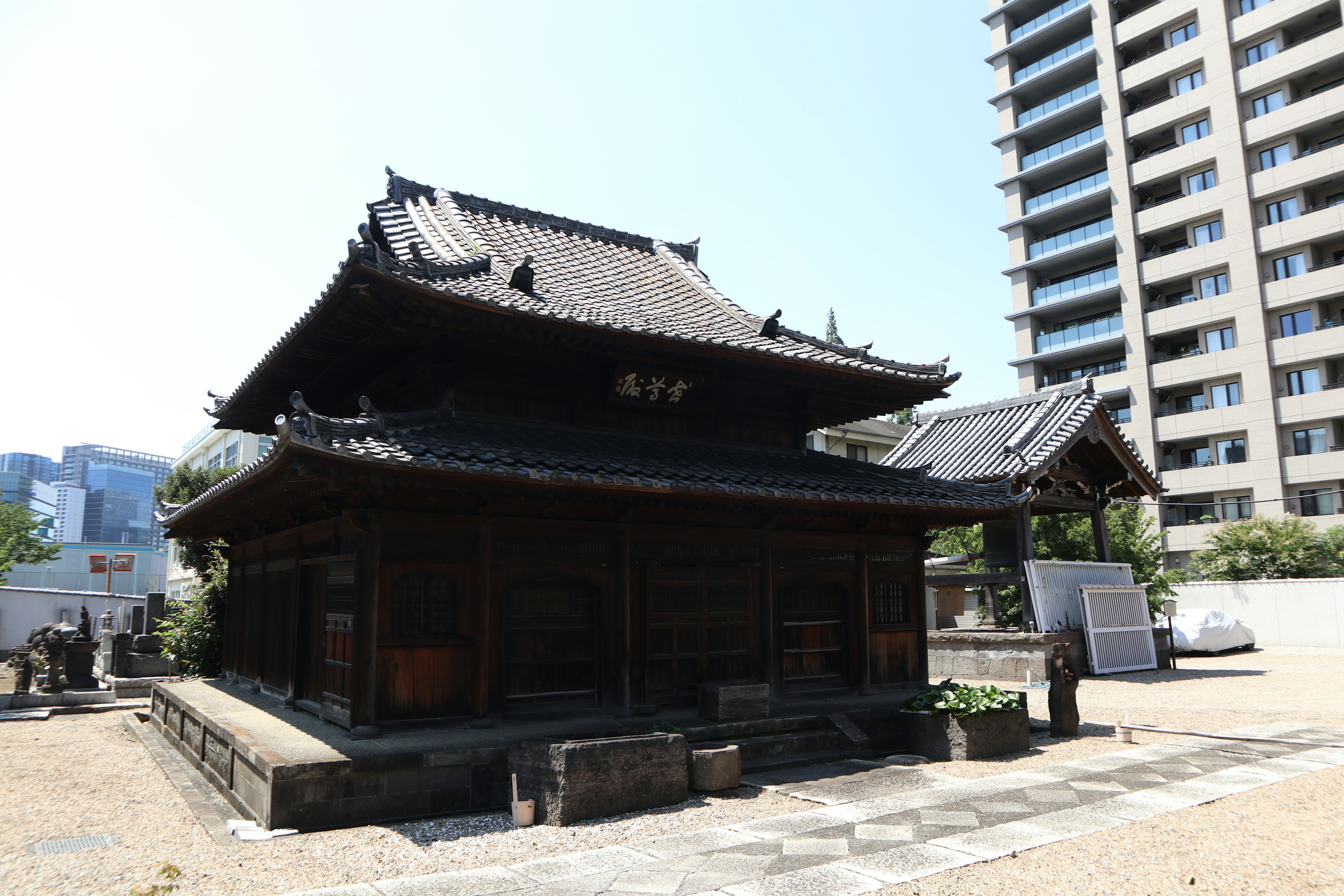 Traditional Japanese building next to a modern skyscraper