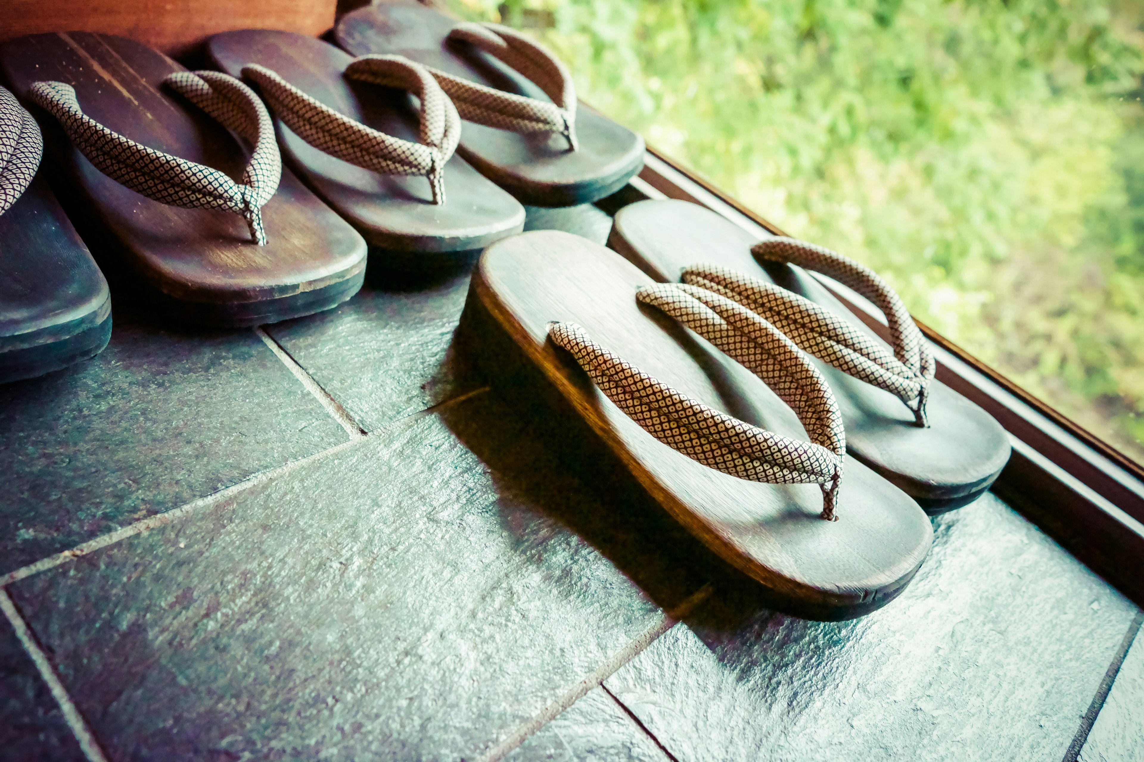 A collection of beach sandals arranged near a doorway